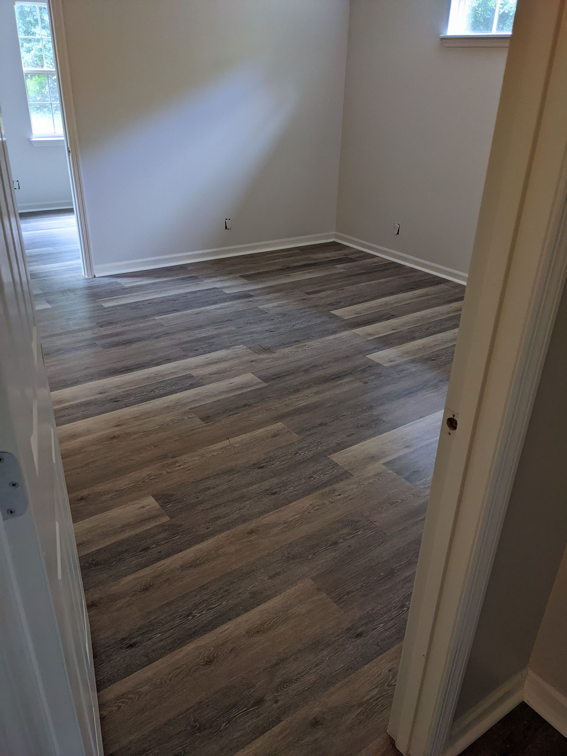 A room with hardwood floors and white walls.