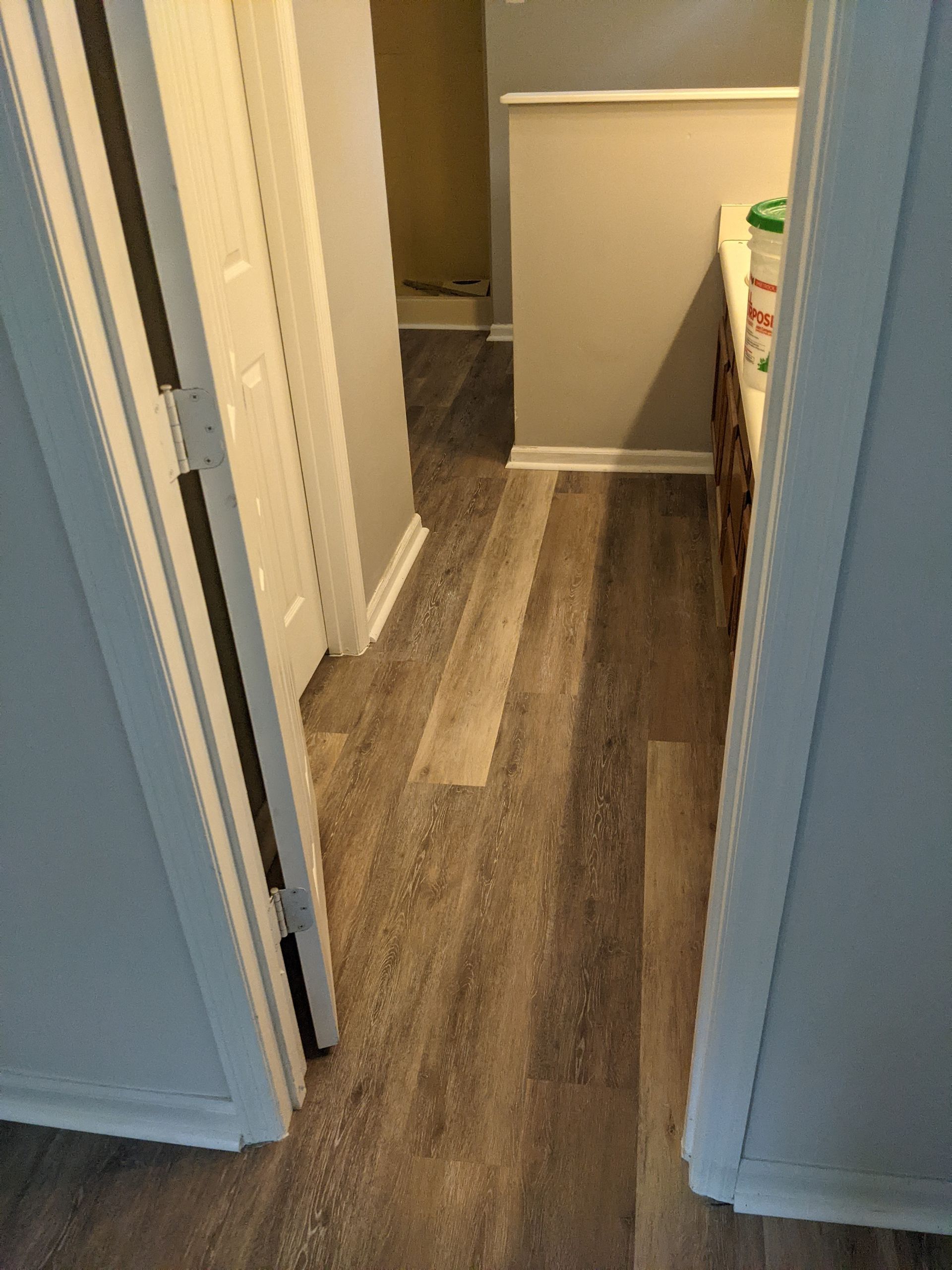 A hallway with hardwood floors in a house.