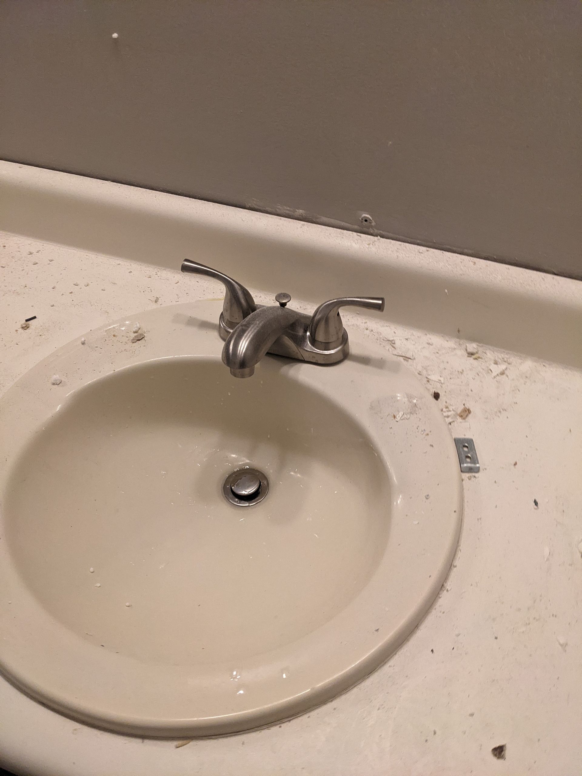 A bathroom sink with a faucet on a white counter top.