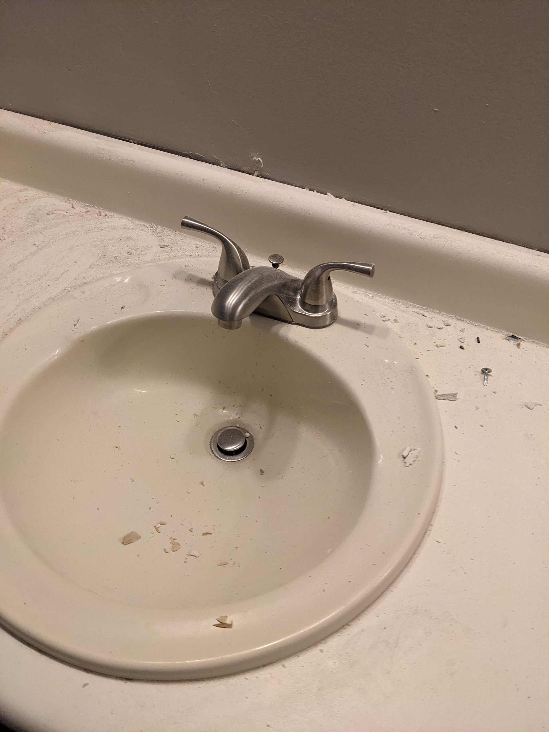 A bathroom sink with a faucet on a white counter top.