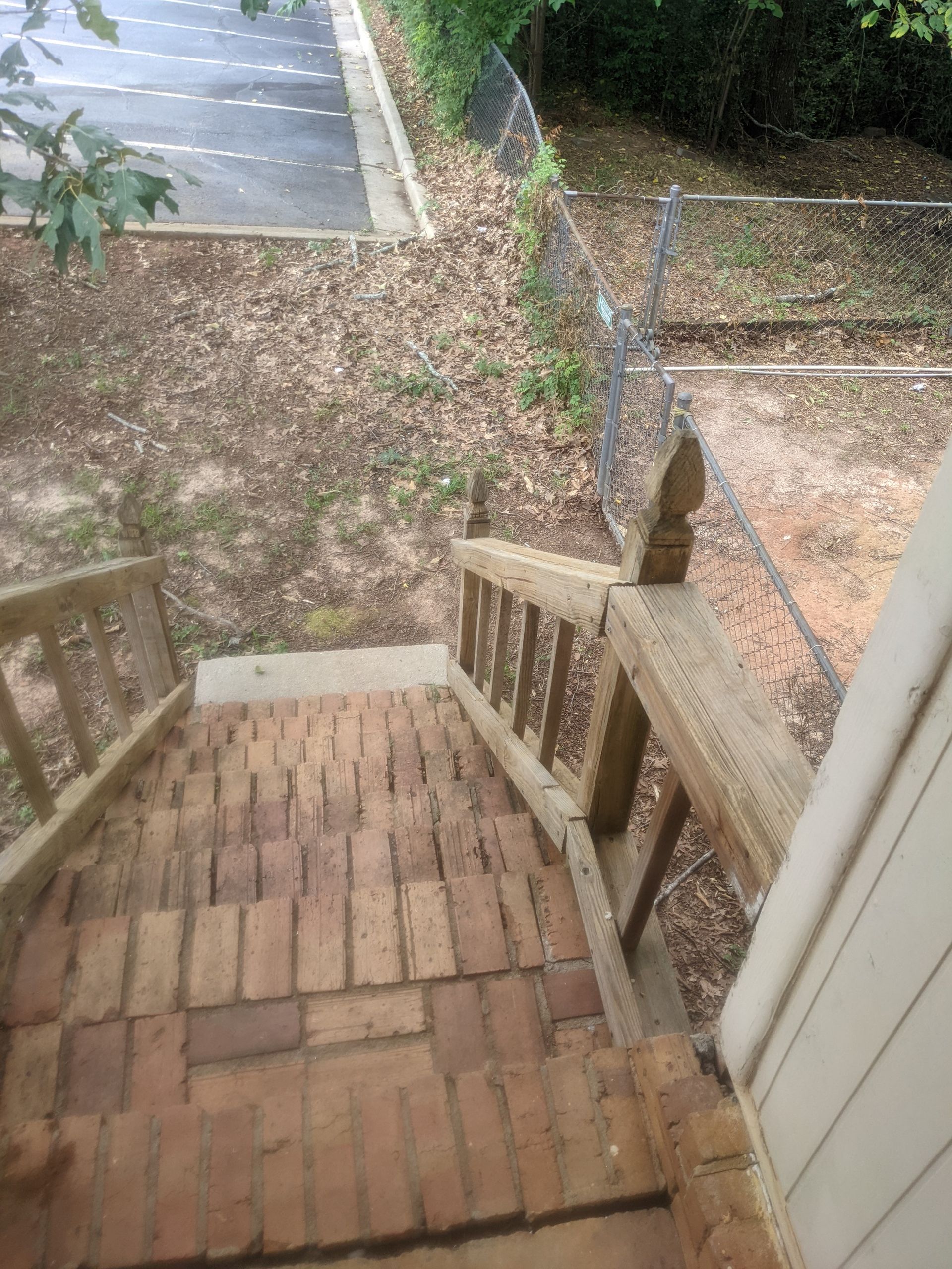 A set of stairs leading up to a house with a wooden railing.