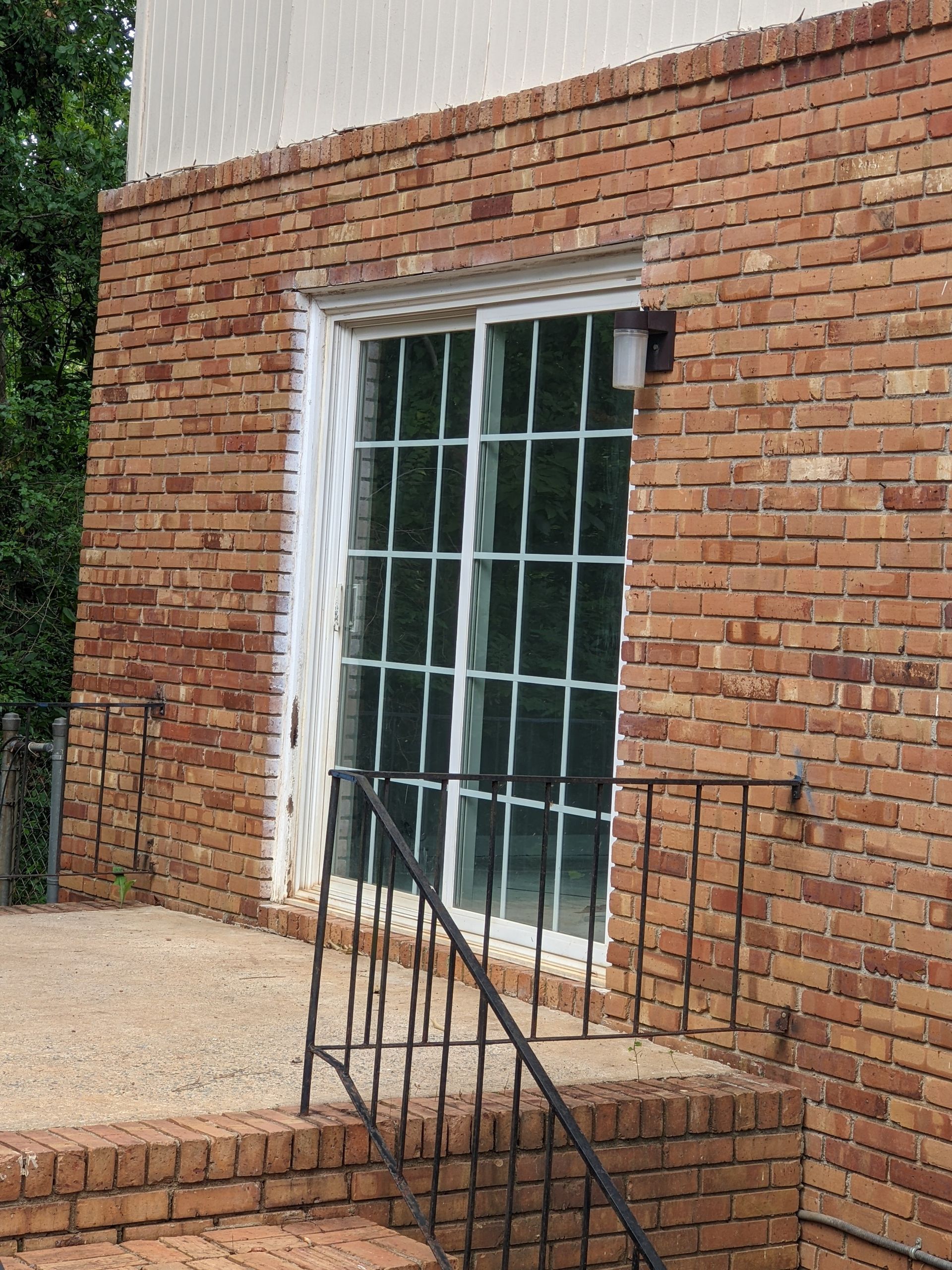 A brick building with a window and stairs leading up to it