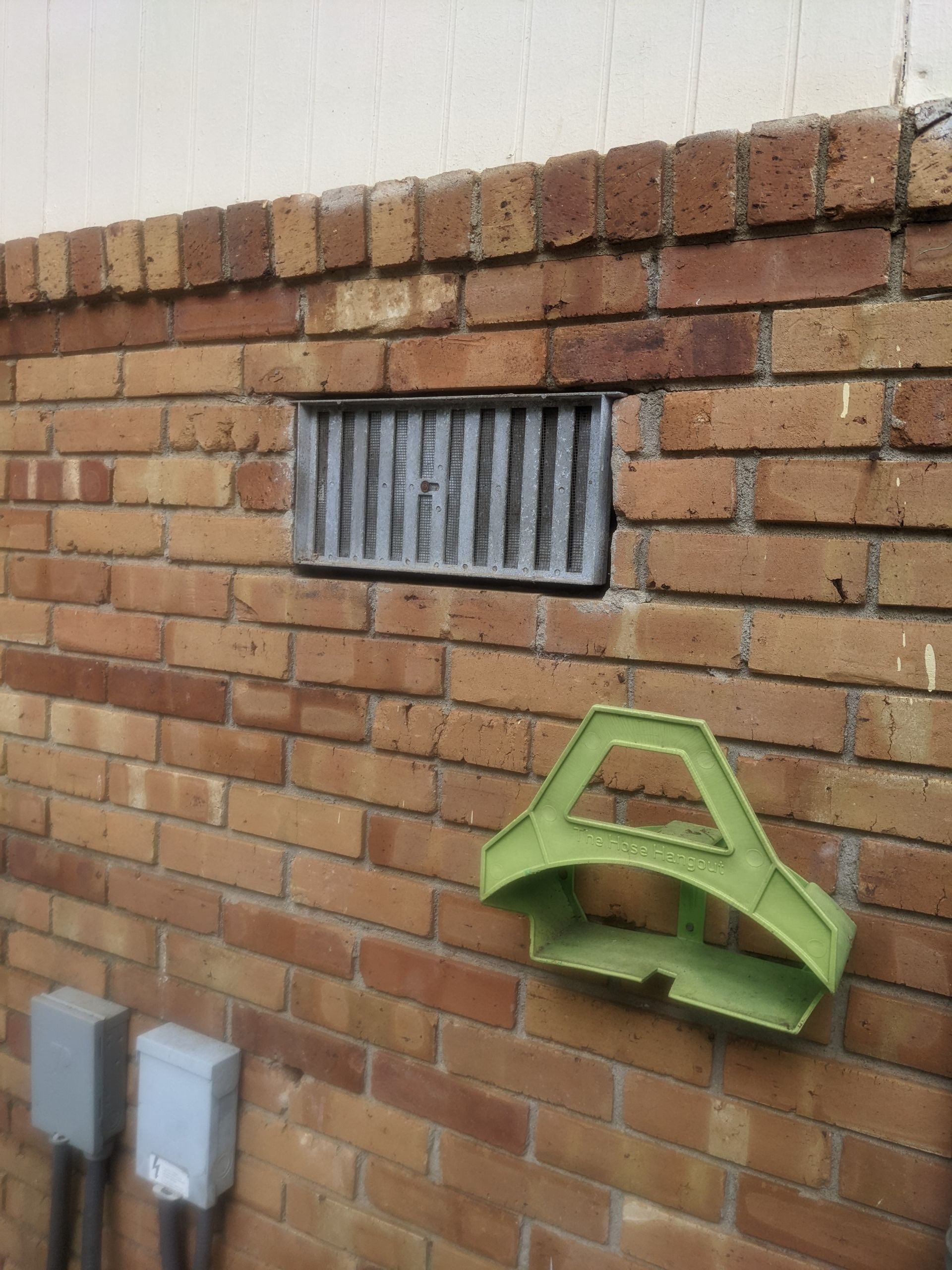 A brick wall with a green object hanging from it