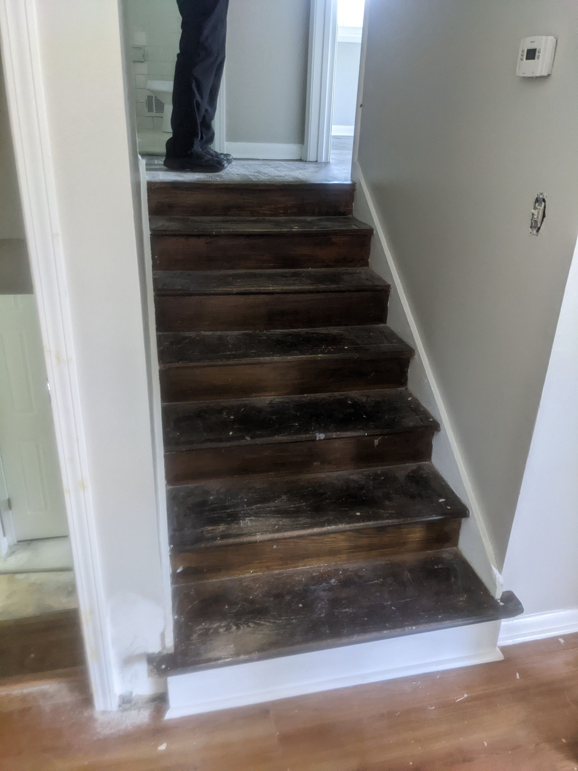 A man is standing on a set of stairs in a house.