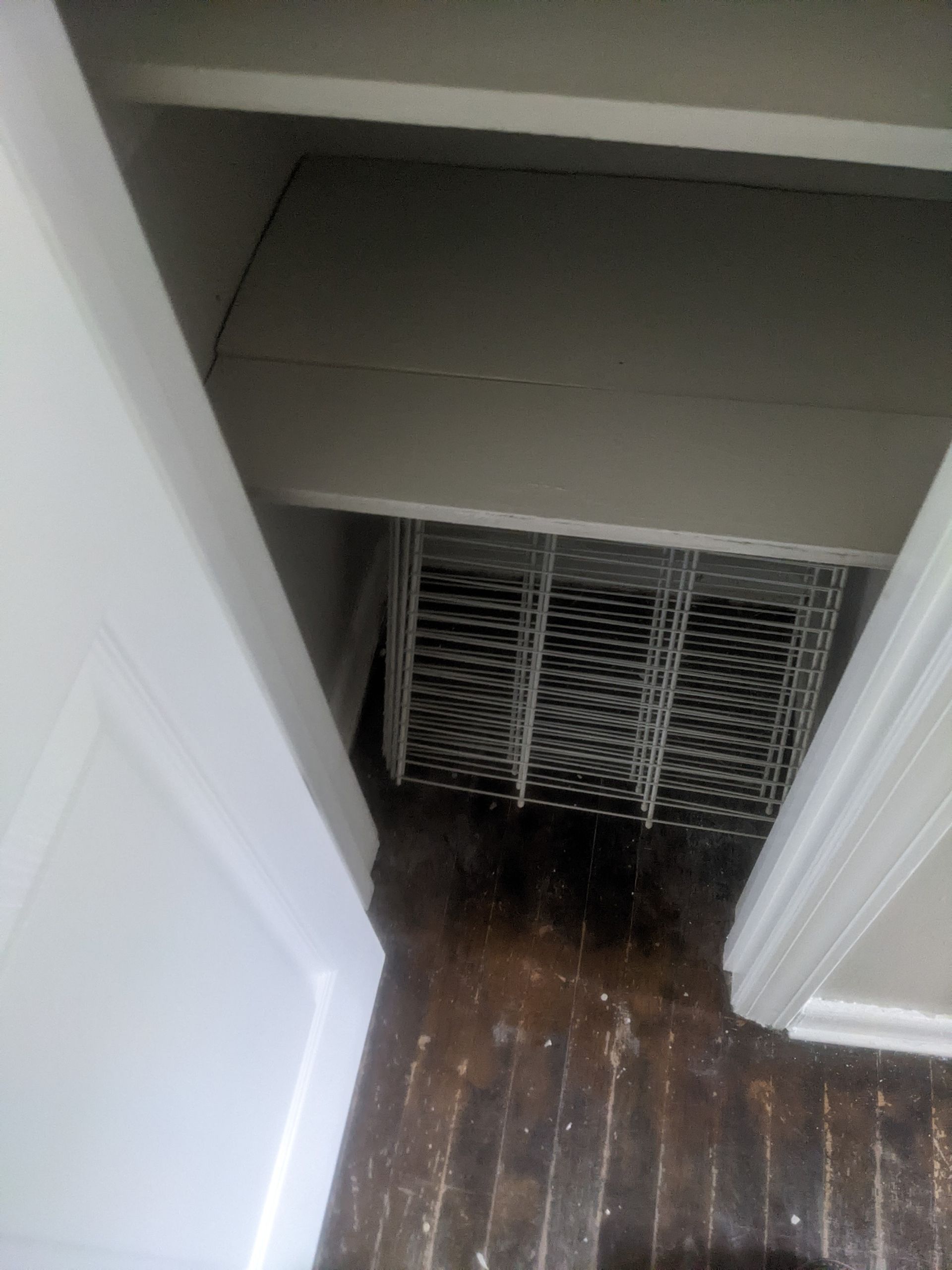 A closet with a basket on top of it and a wooden floor.