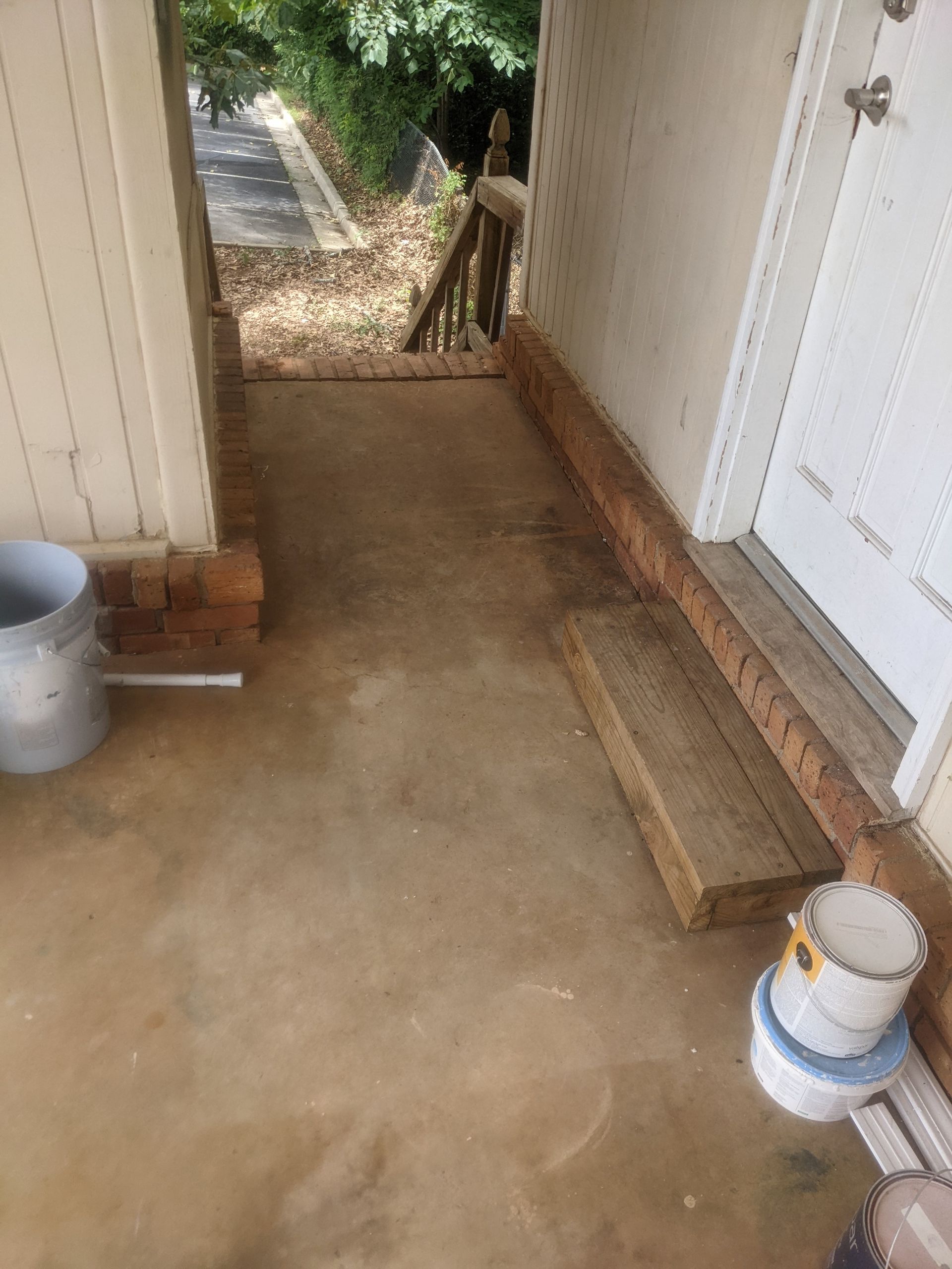 A concrete walkway leading to the front door of a house.