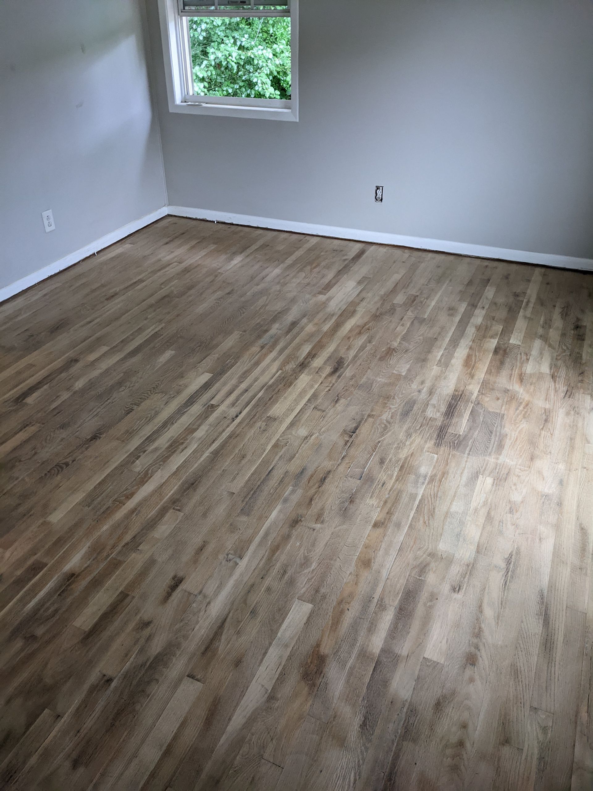 A room with a wooden floor and a window.