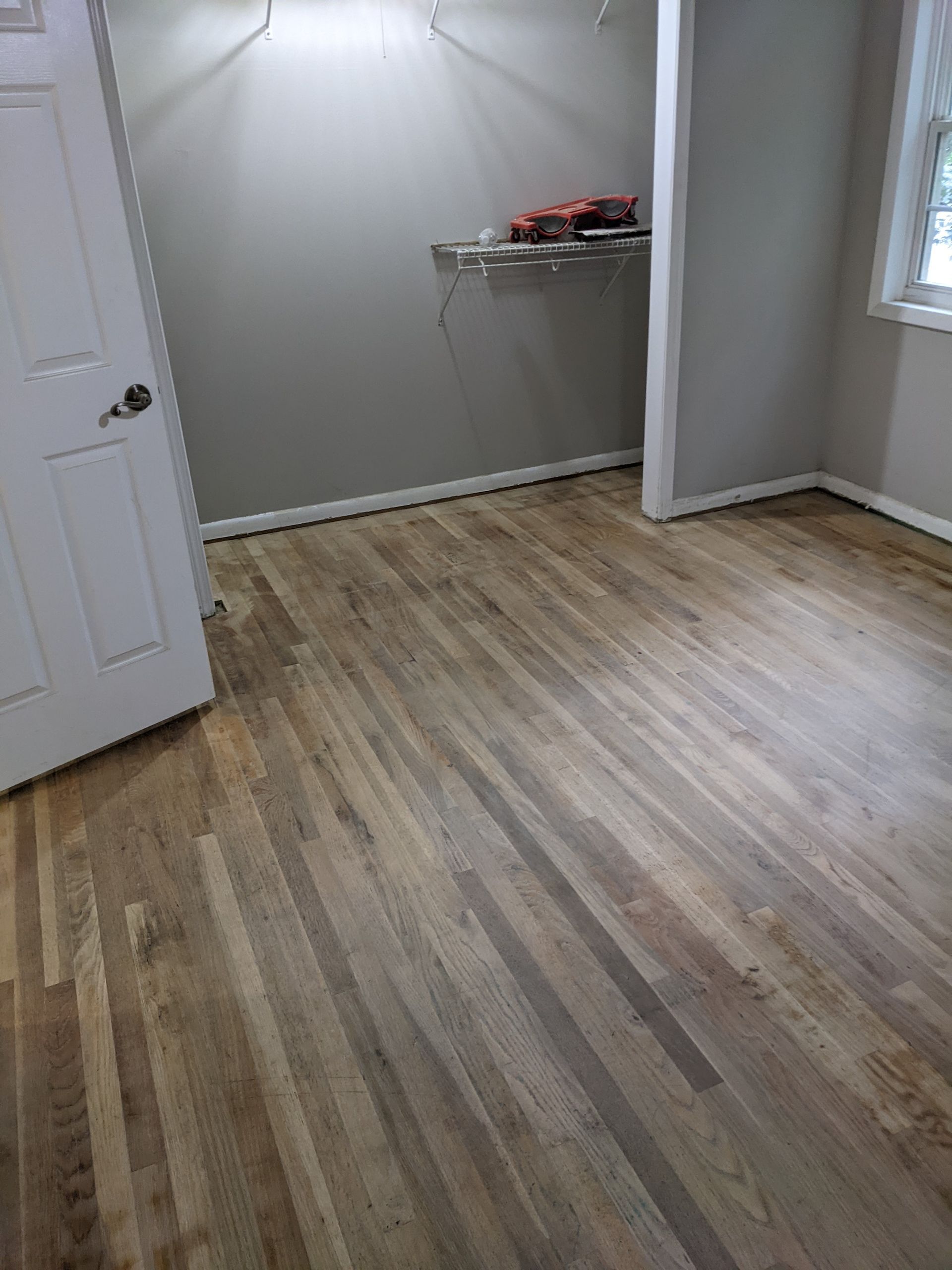 A room with hardwood floors and a white door.
