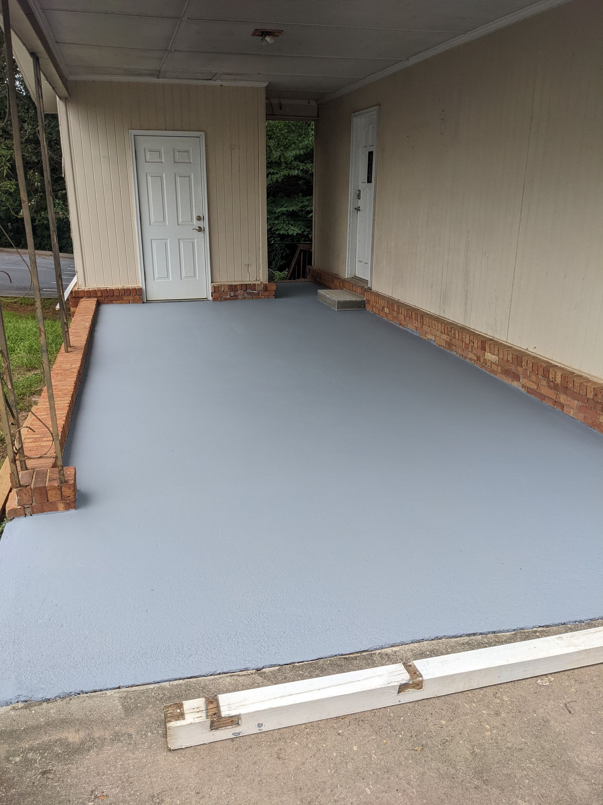 A garage with a concrete floor and a porch.
