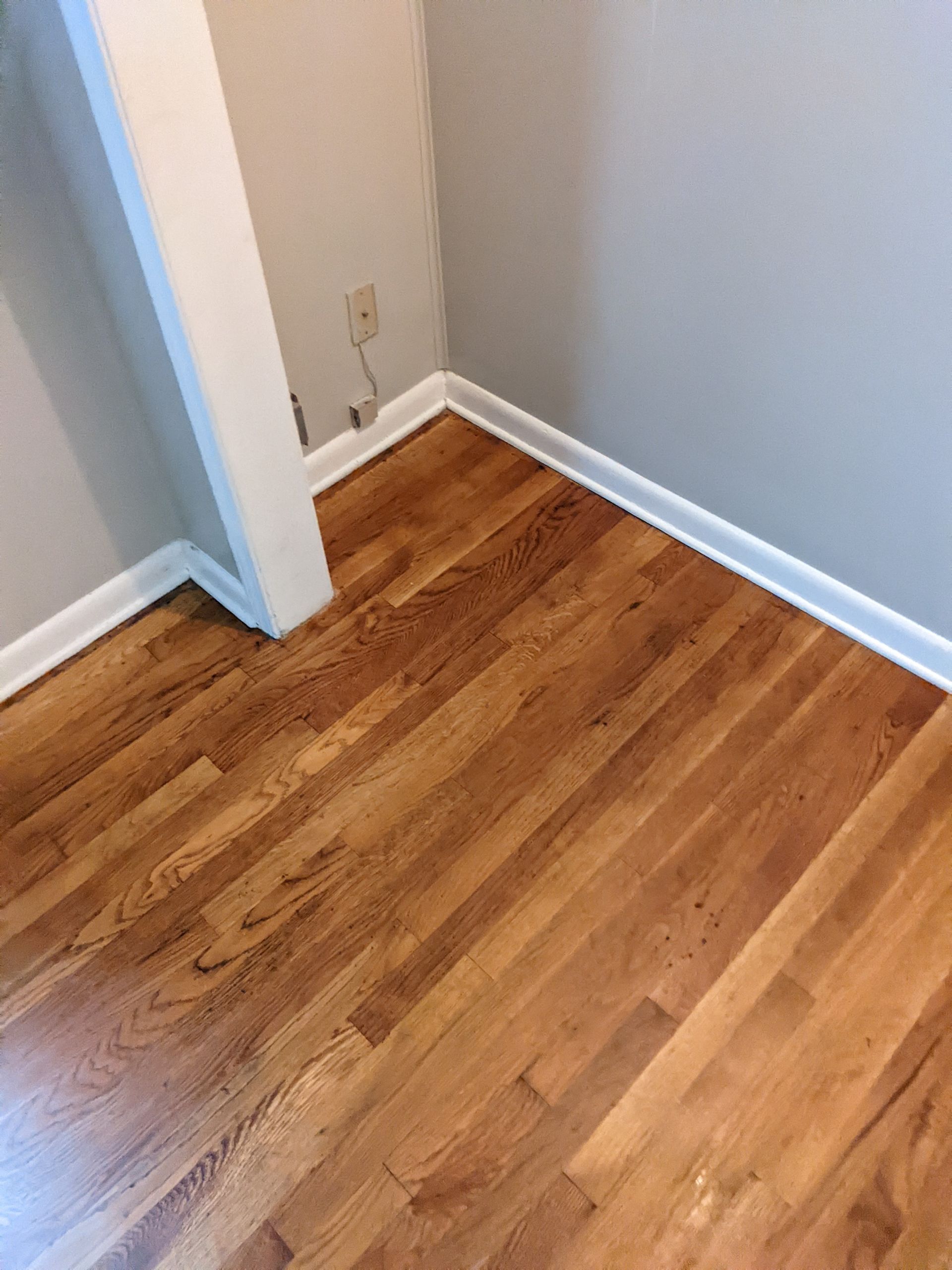 A room with hardwood floors and white trim in a house.