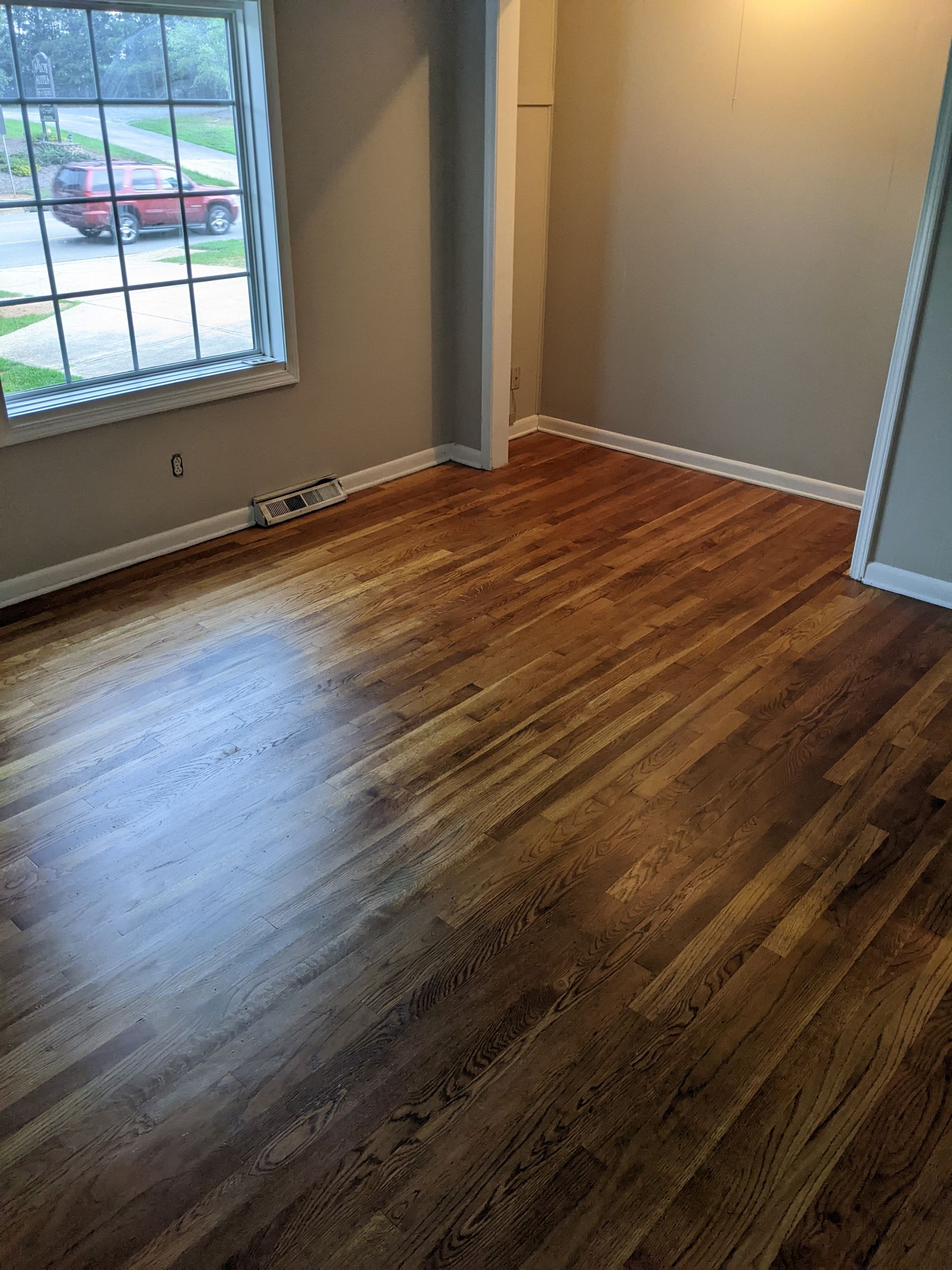 A living room with hardwood floors and a window.