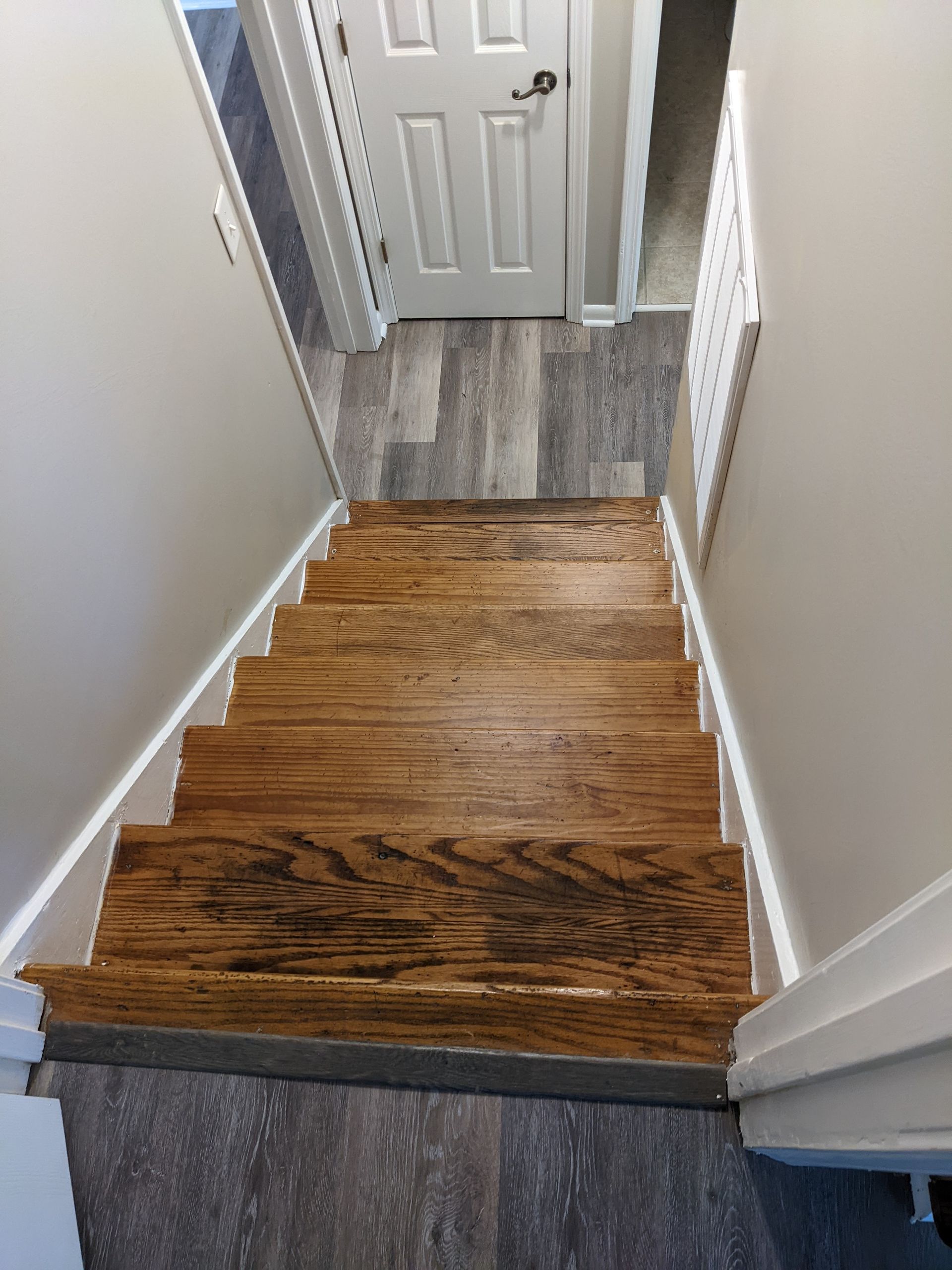A wooden staircase leading up to a door in a house.