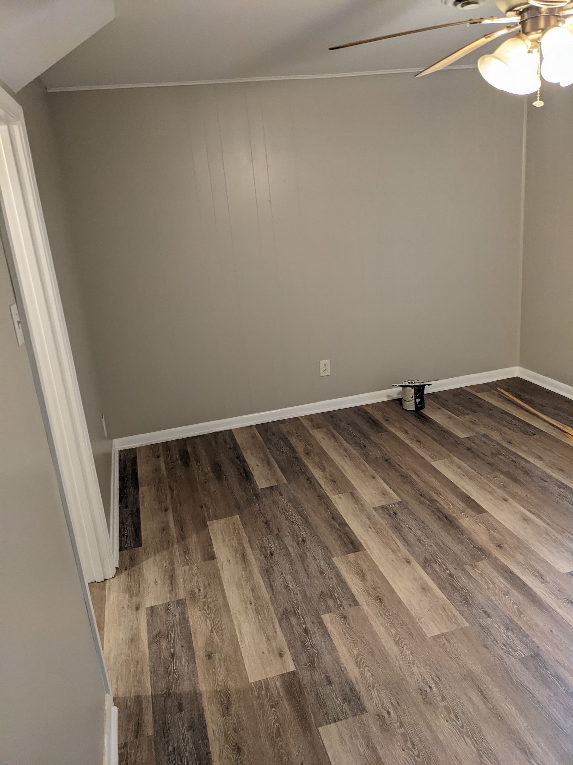 A living room with hardwood floors and a ceiling fan.