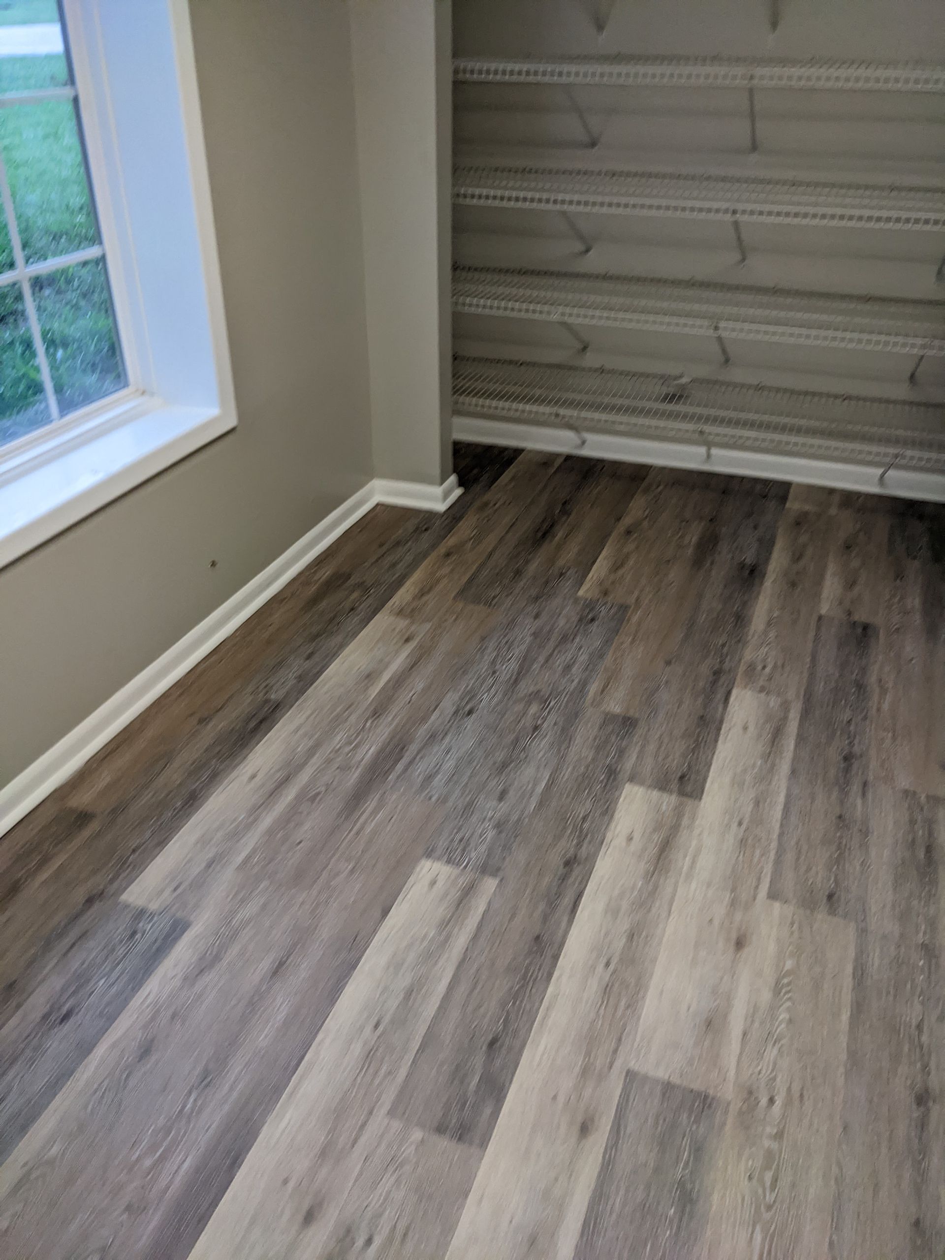 A room with hardwood floors and a window.