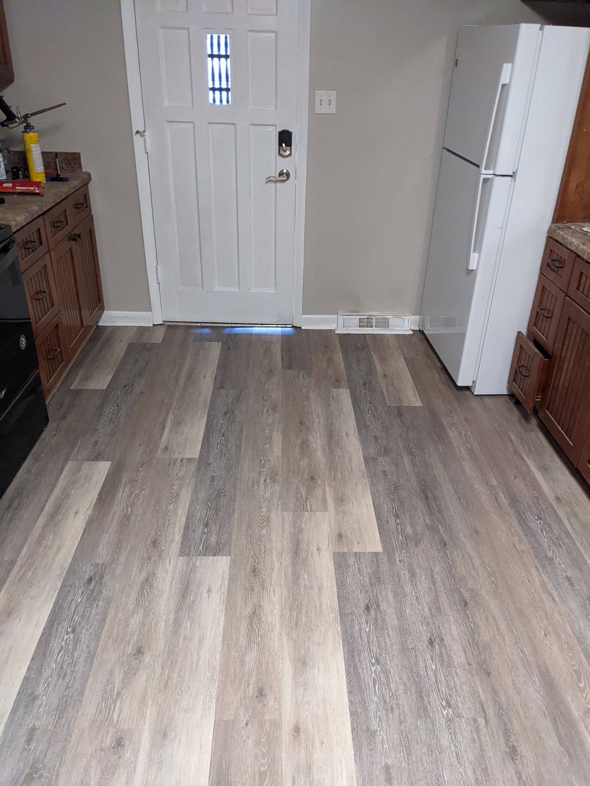 A kitchen with hardwood floors and a refrigerator.