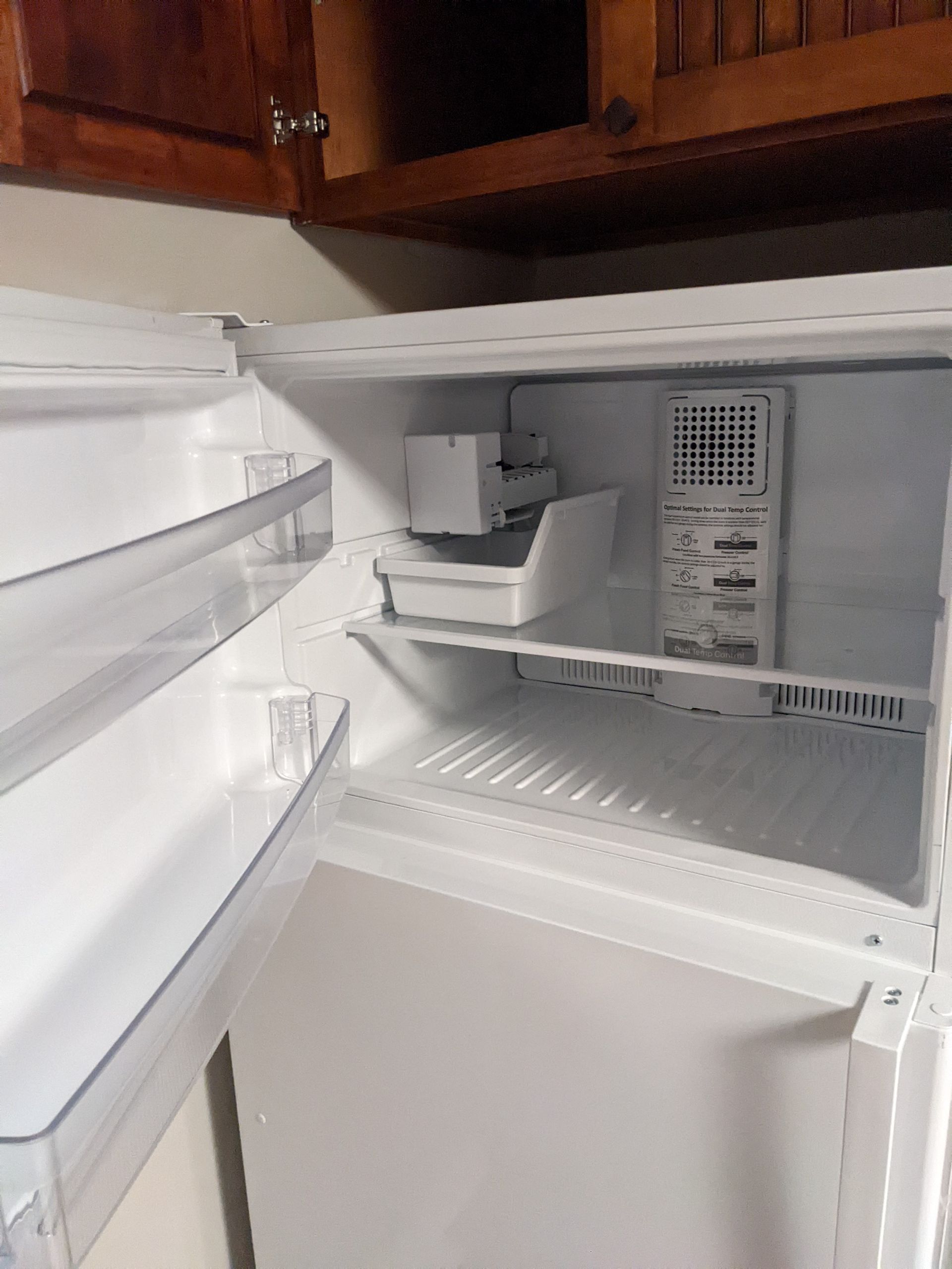 The inside of an empty refrigerator with the door open.