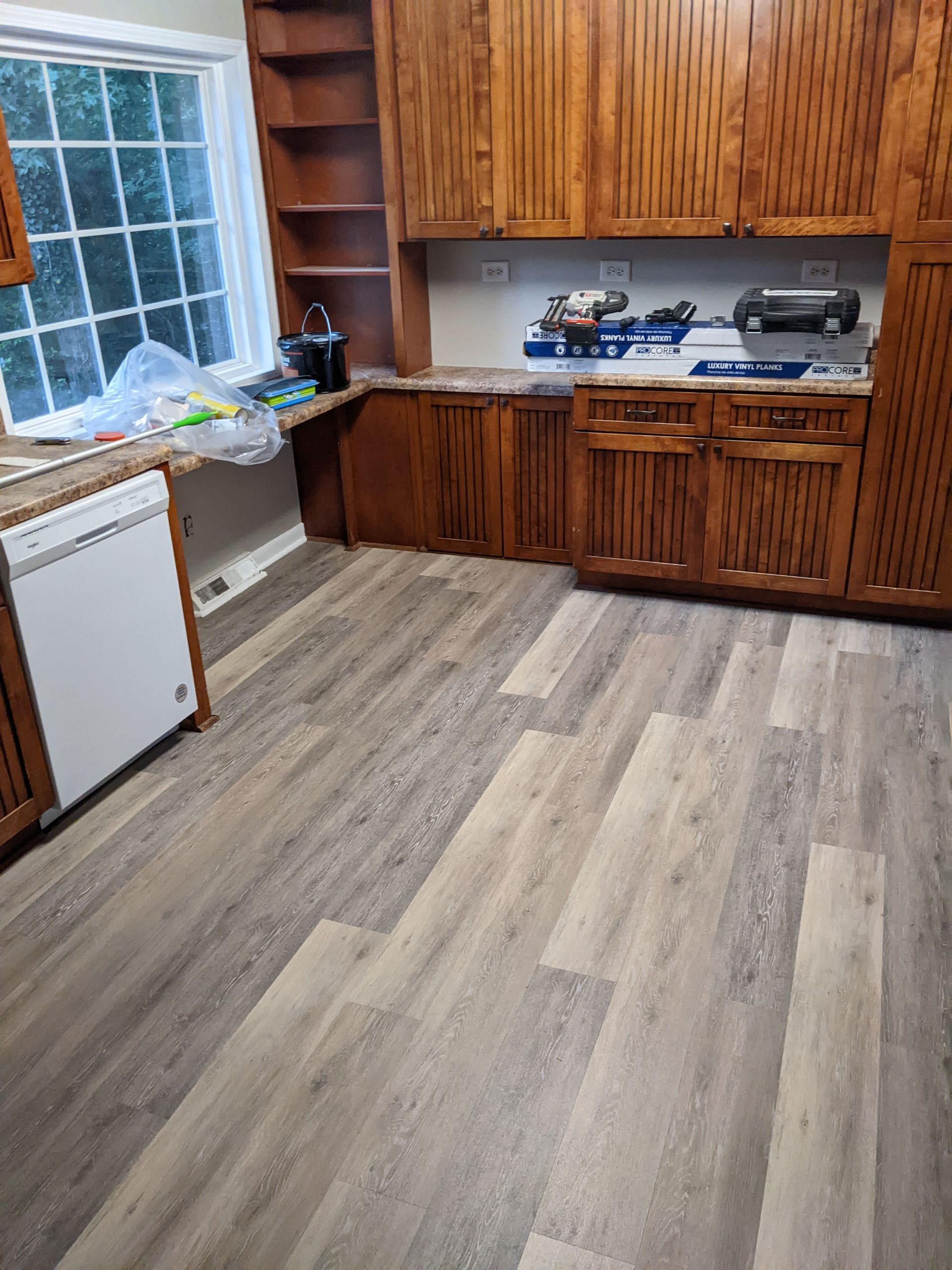 A kitchen with wooden cabinets and a wooden floor.