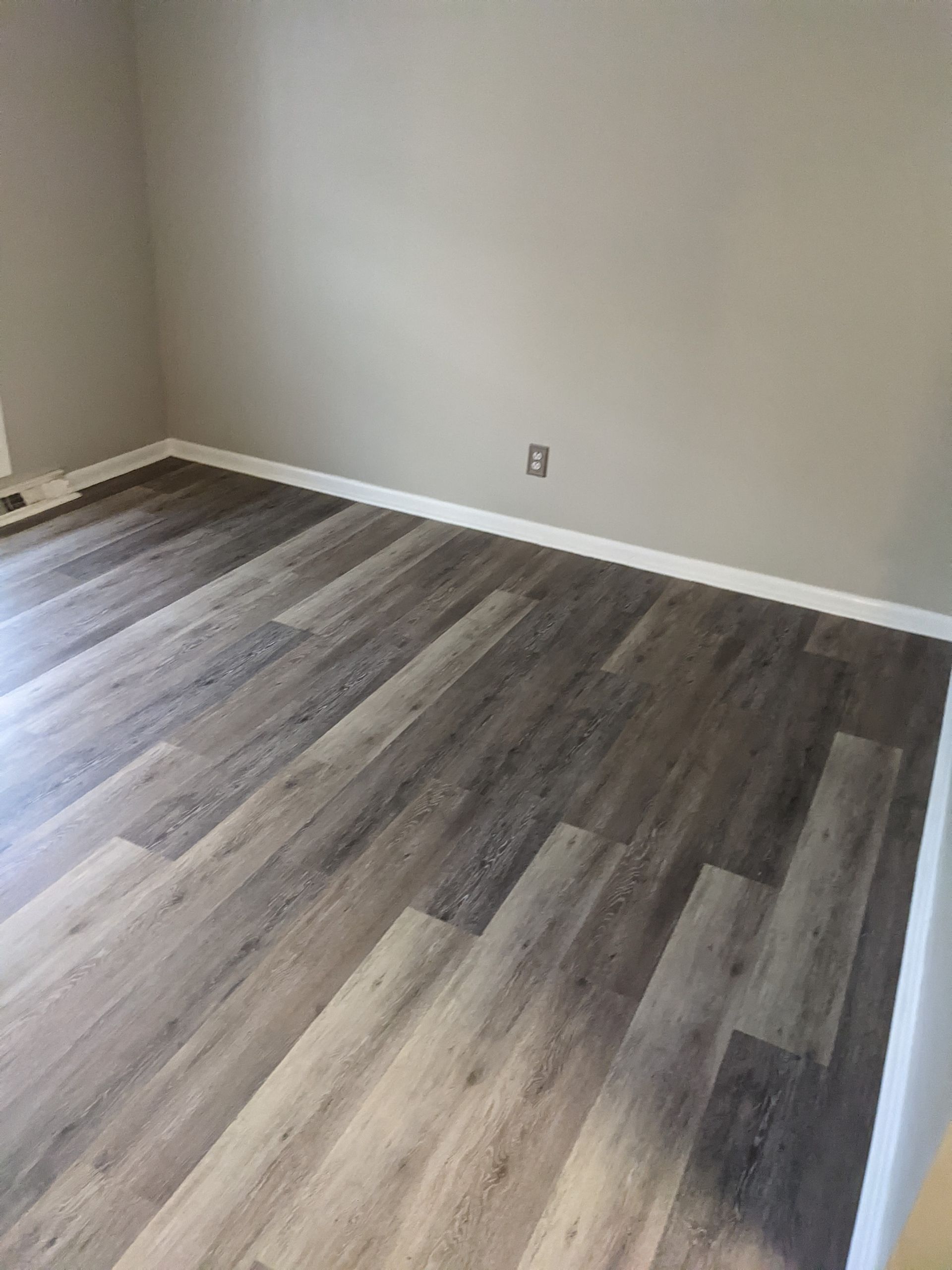 A living room with hardwood floors and gray walls.