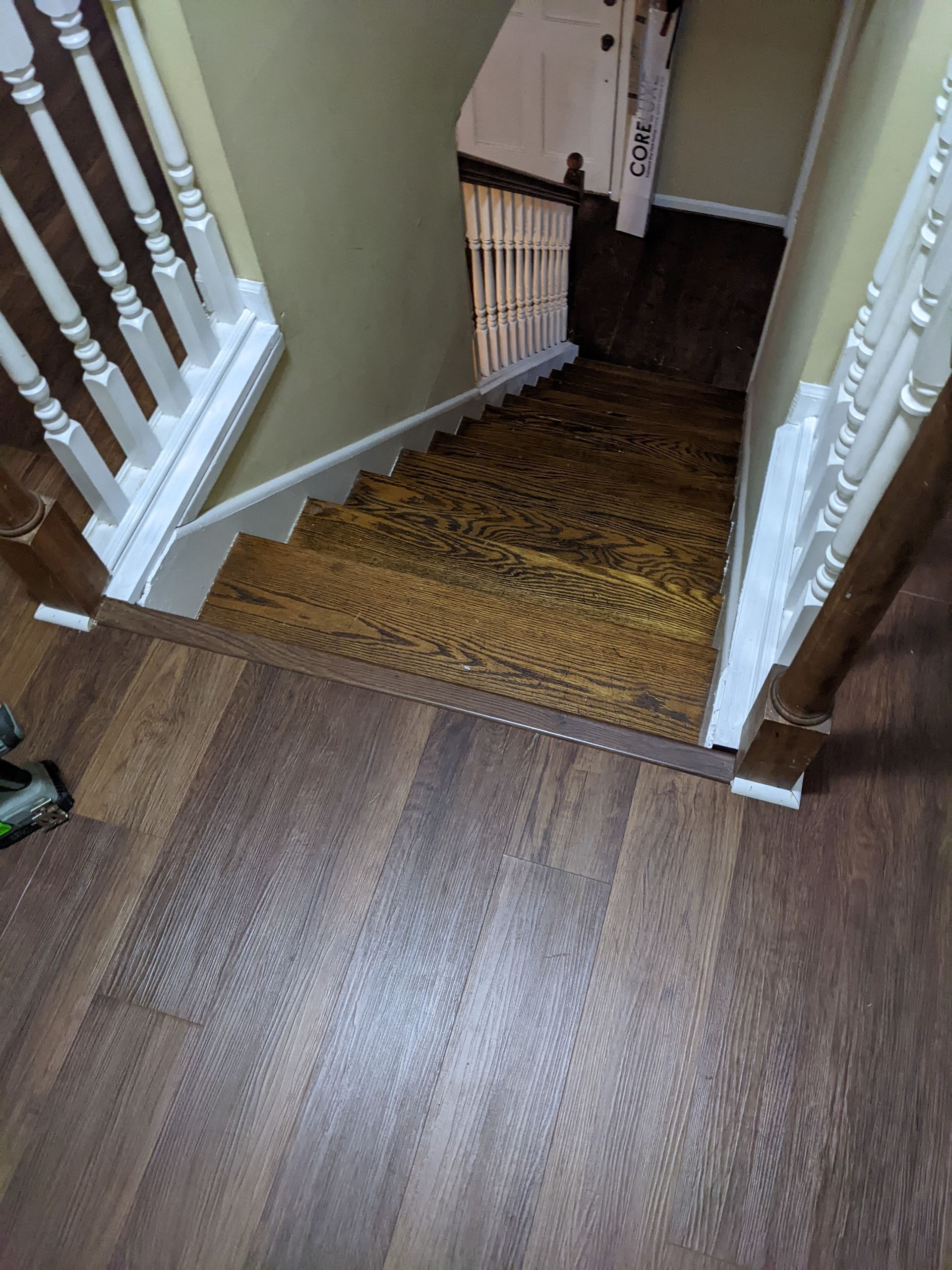 A wooden staircase with a white railing and a wooden floor.