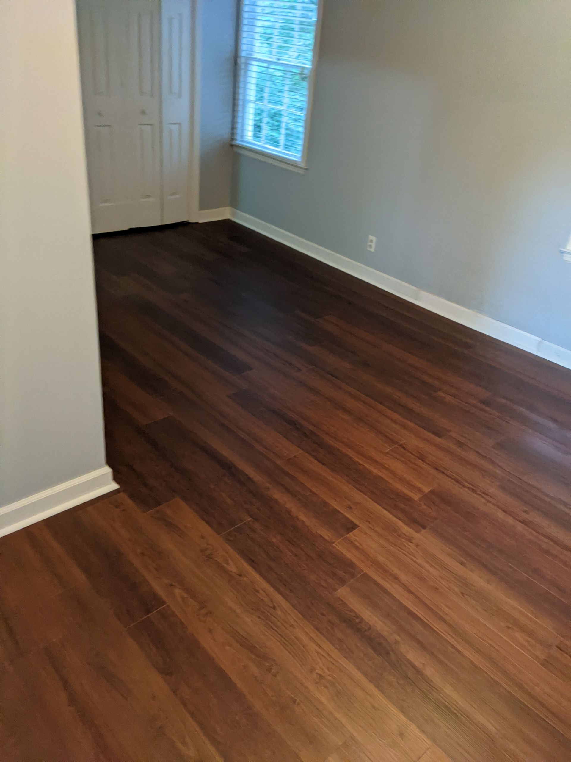 A room with a wooden floor and a window.