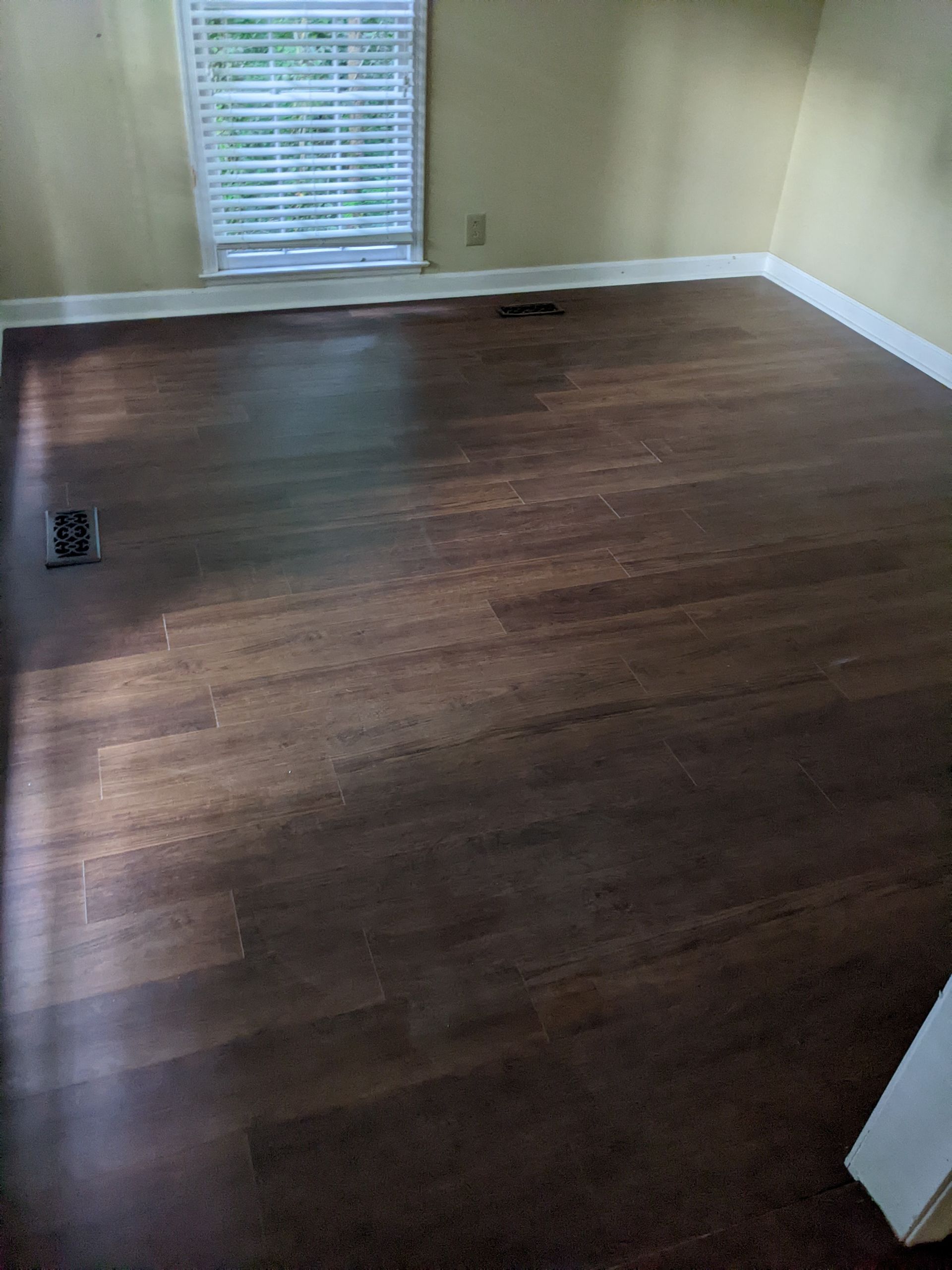A living room with hardwood floors and a window.