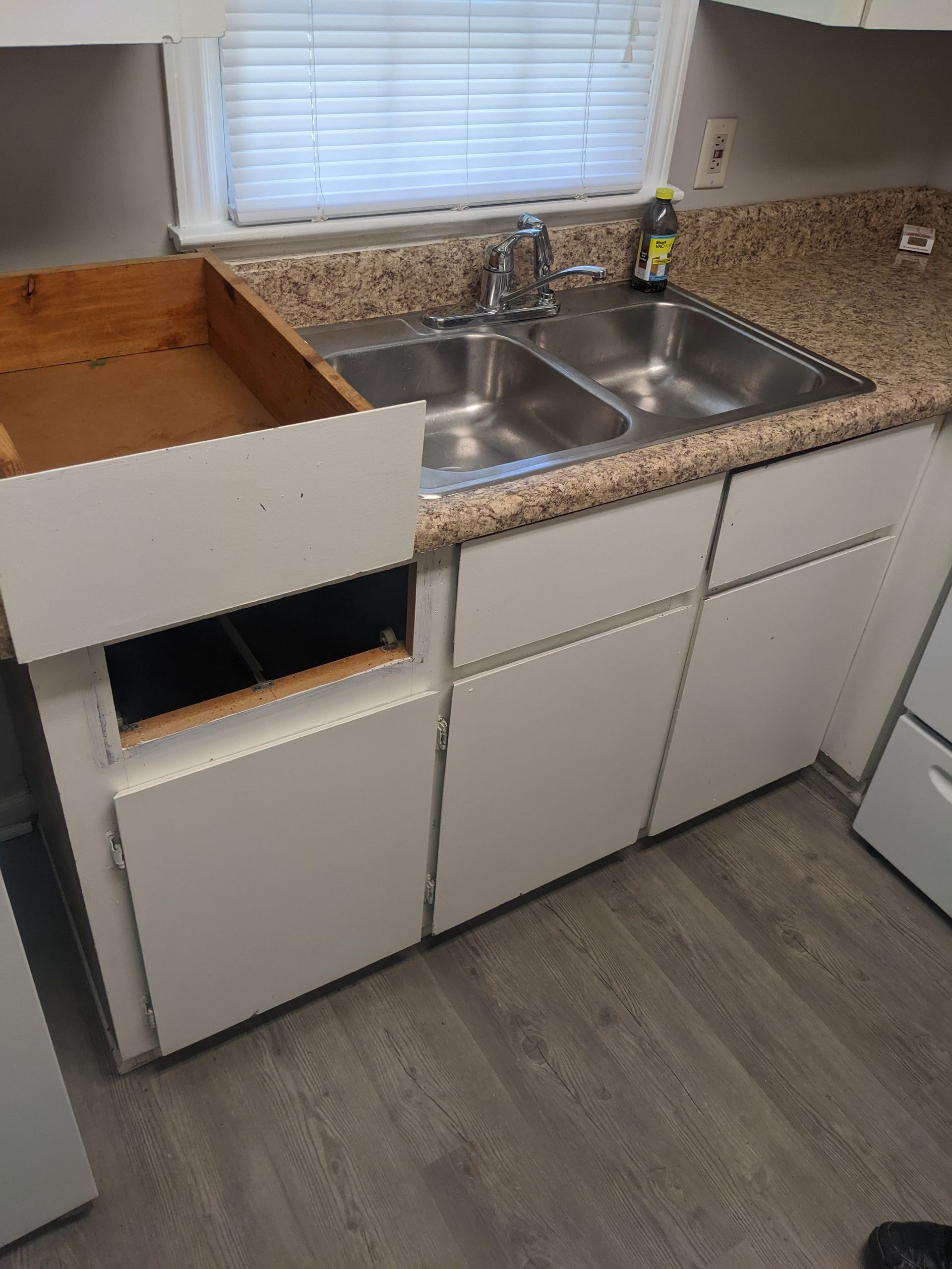 A kitchen with two sinks , a stove , and a window.