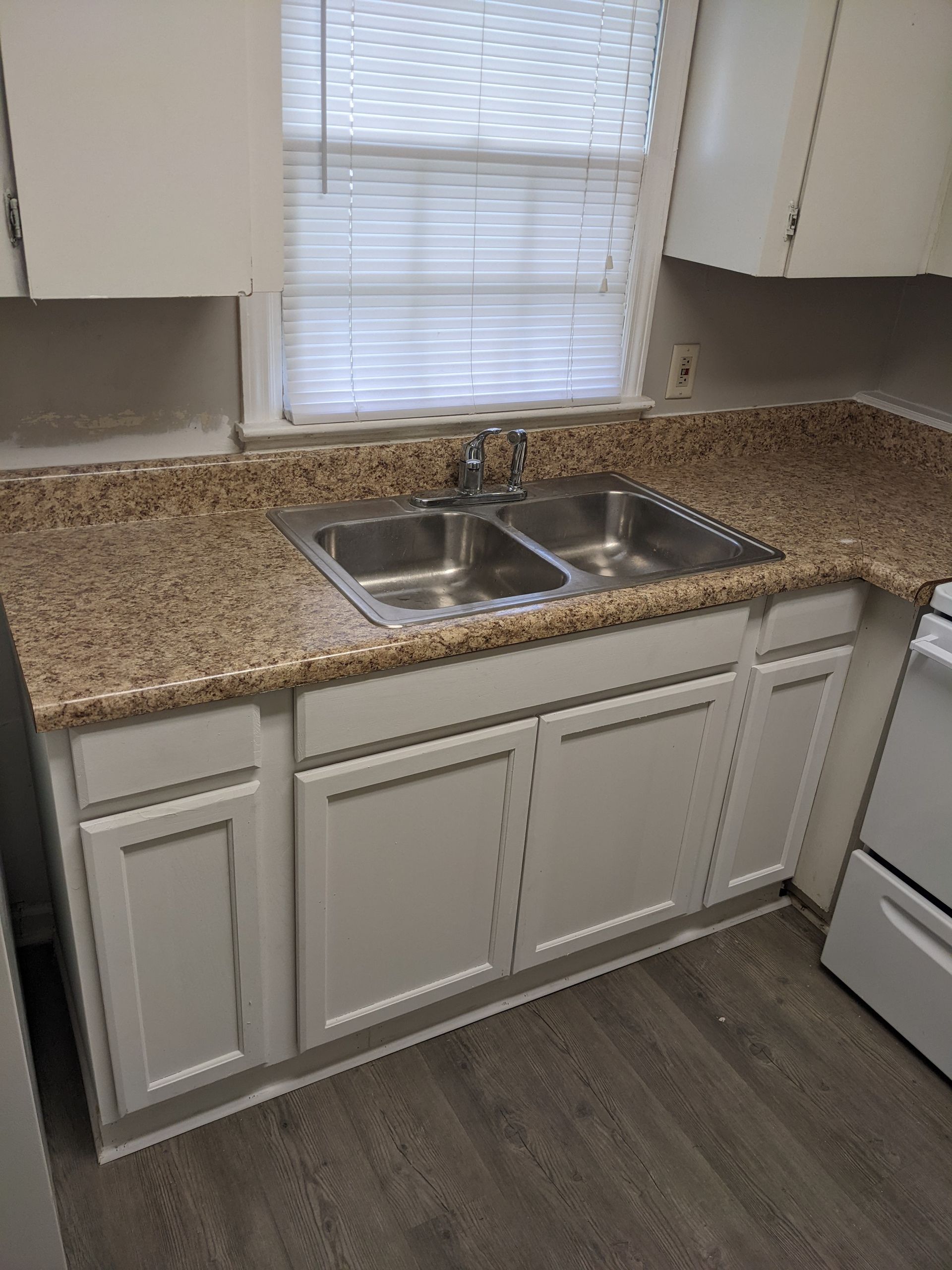 A kitchen with two sinks , a stove , and a window.