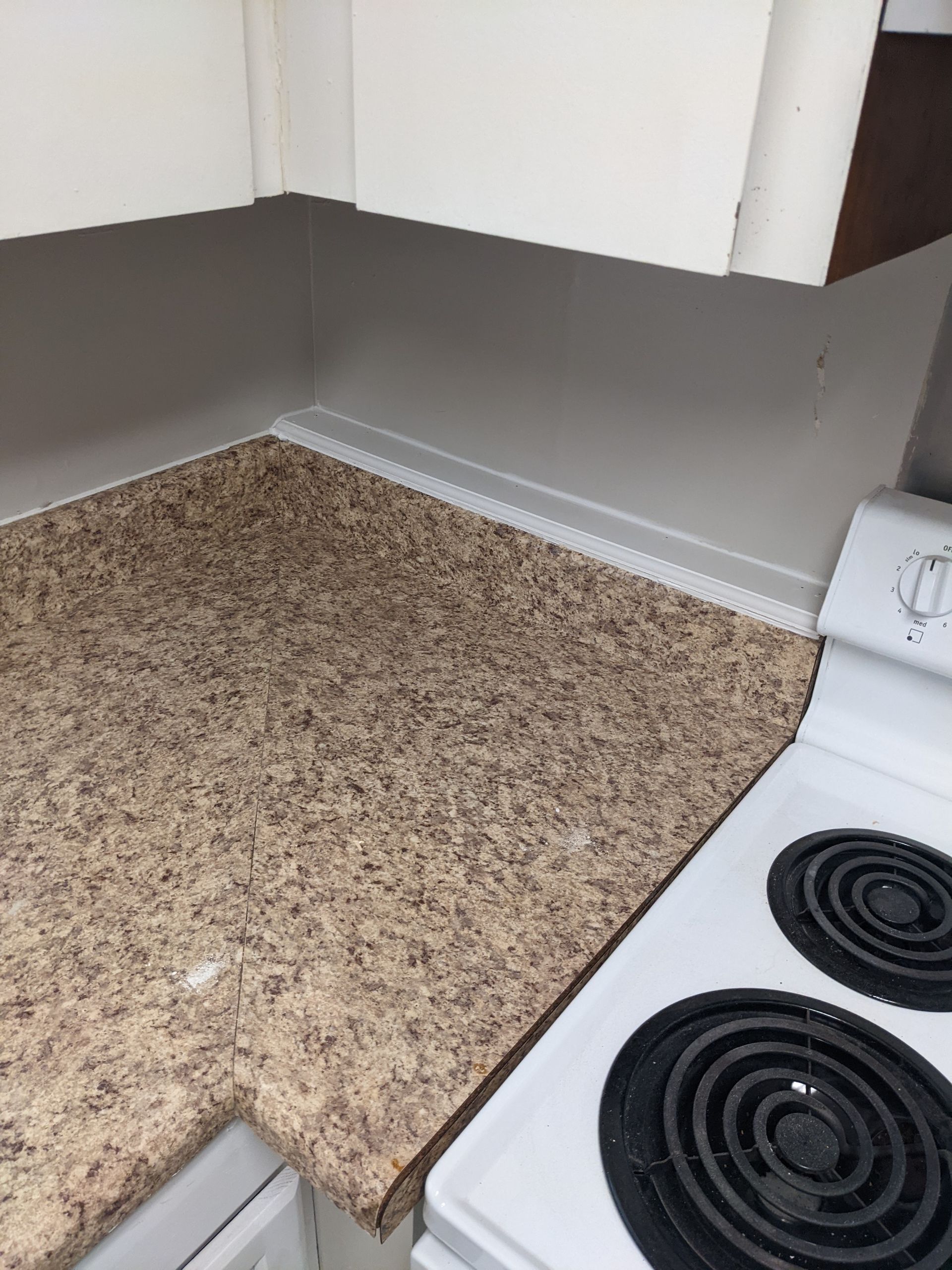 A kitchen with a granite counter top and a white stove top