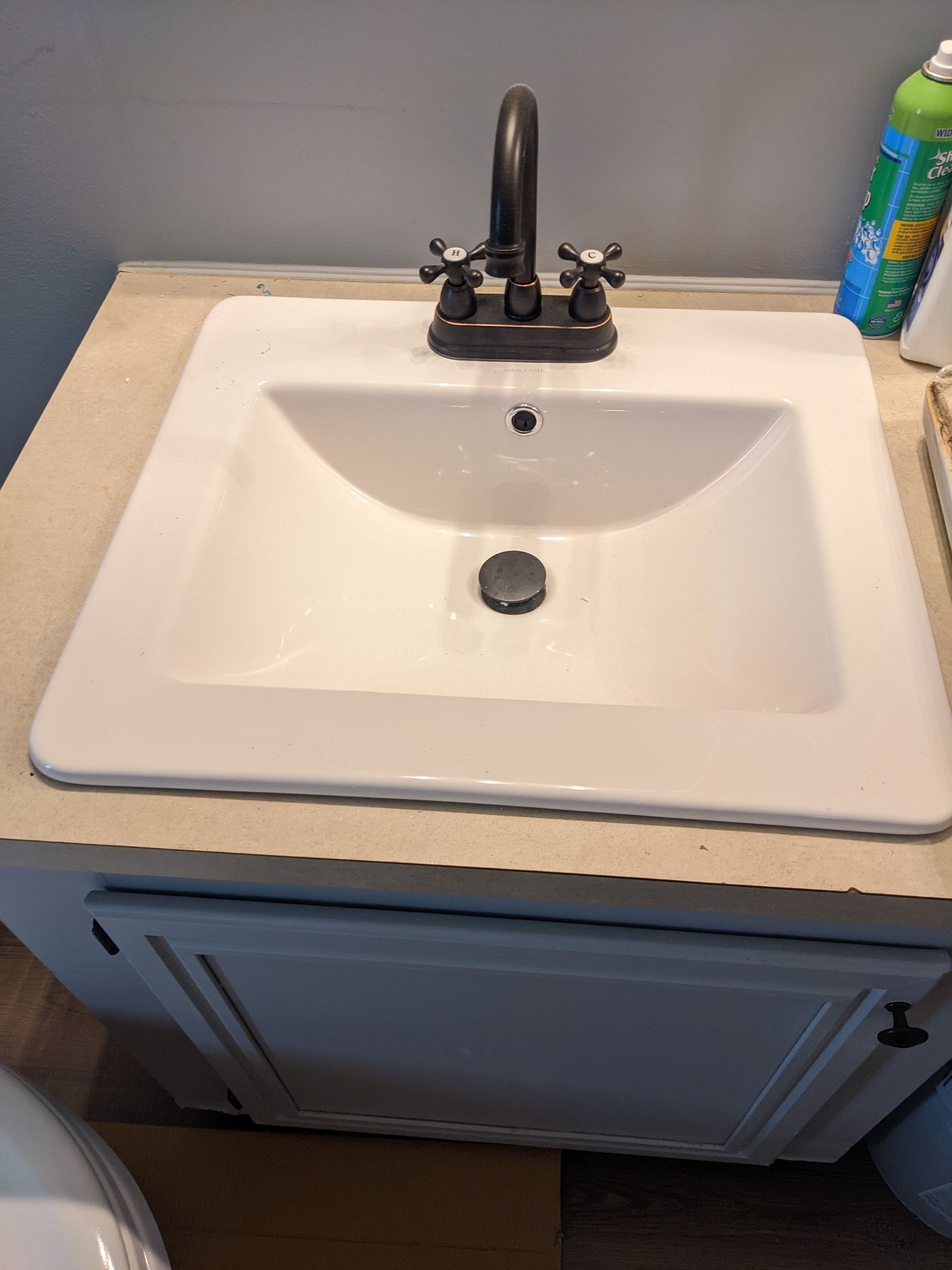 A bathroom sink is sitting on top of a counter next to a toilet.