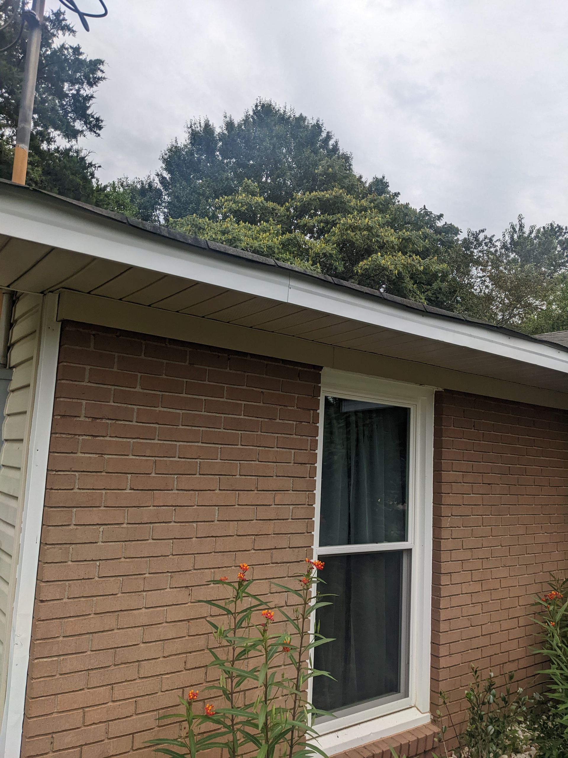 A brick house with a window and a roof.
