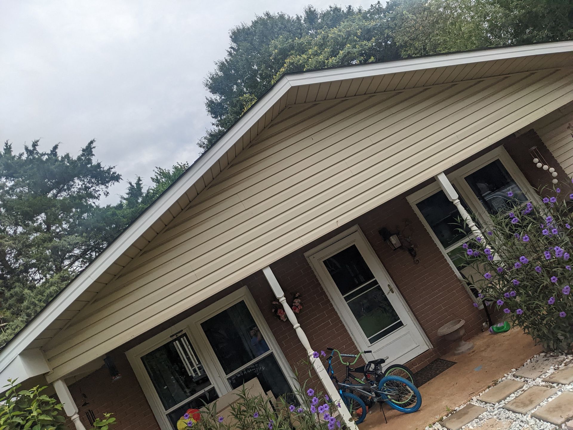 A bicycle is parked on the porch of a house