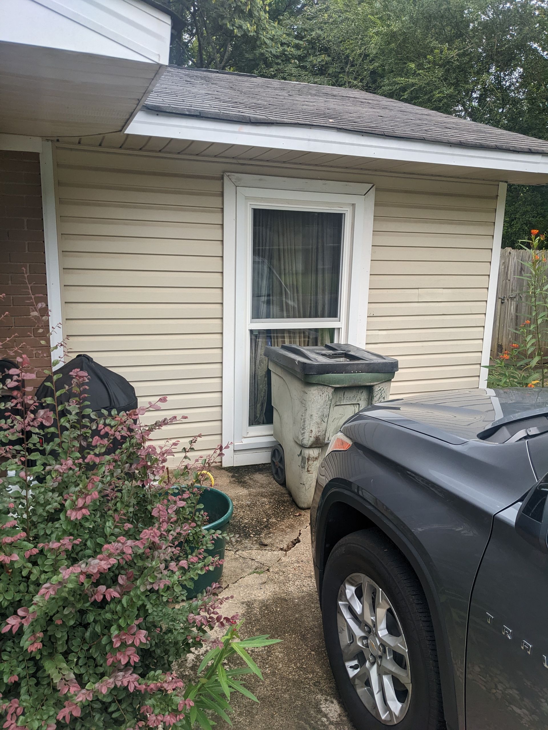 A black truck is parked in front of a house.