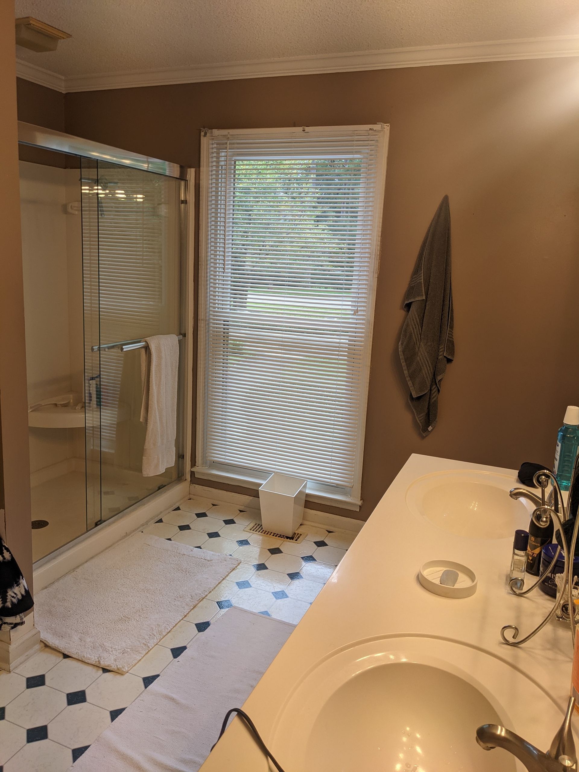 A bathroom with a sink and a window with blinds