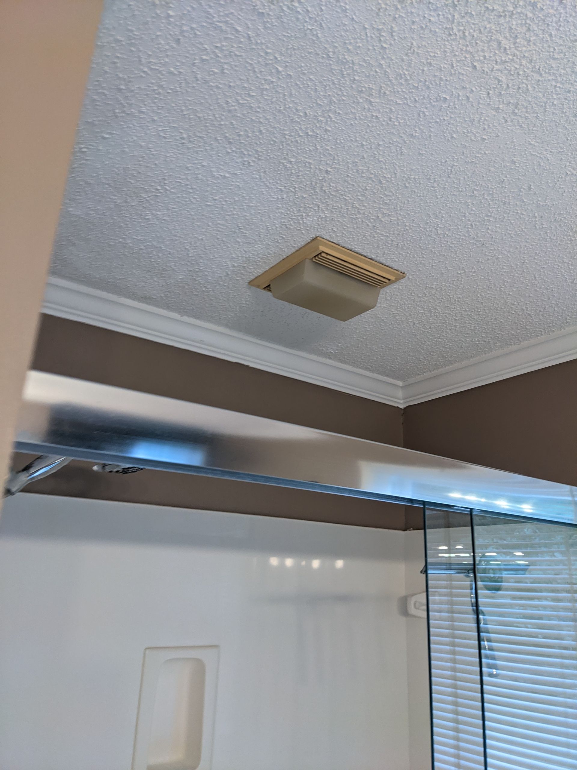 A bathroom with a shower and a ceiling fan
