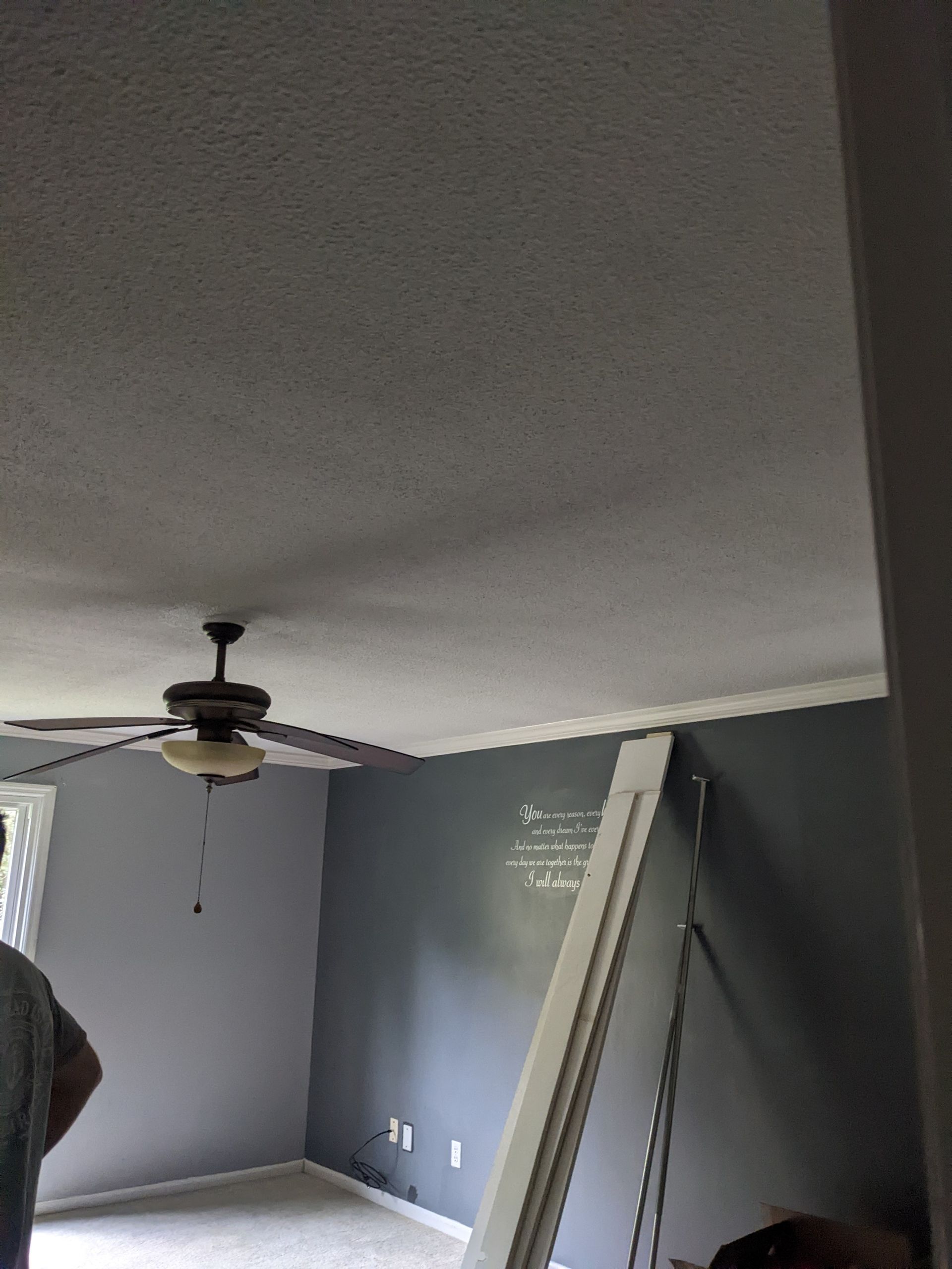 A ceiling fan is hanging from the ceiling of a room.