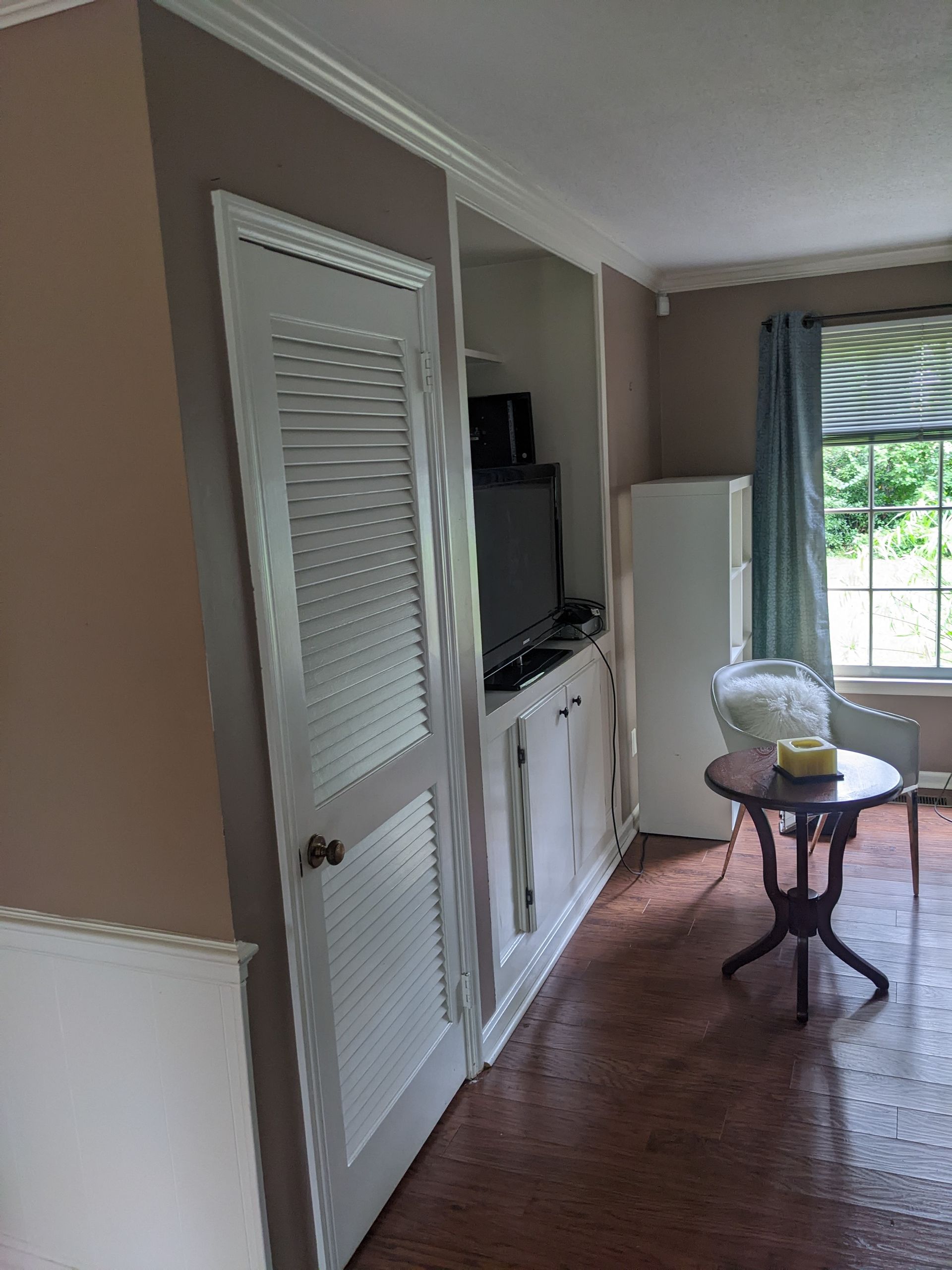 A living room with a table and chairs and a television.