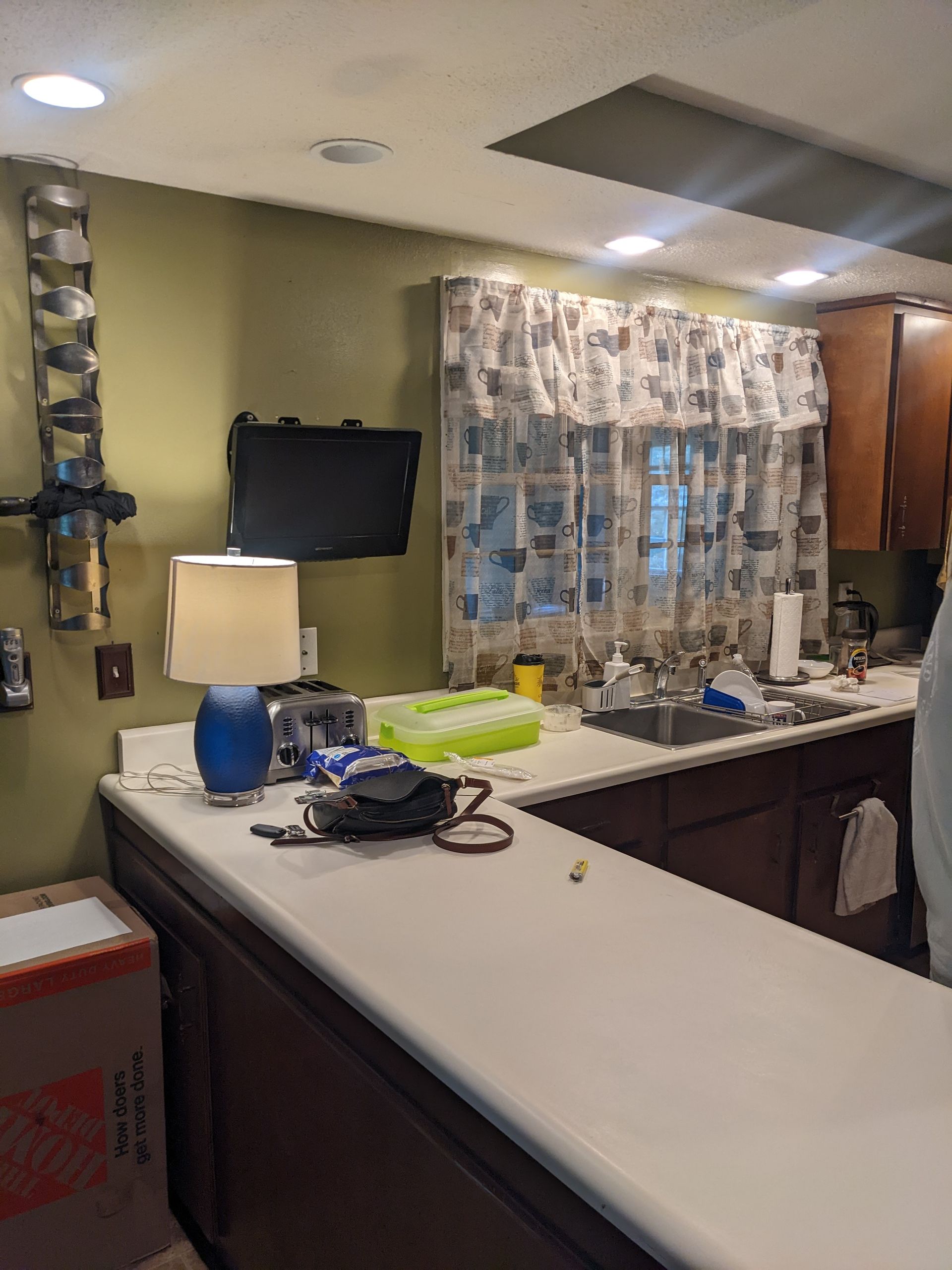 A kitchen with a sink and a lamp on the counter