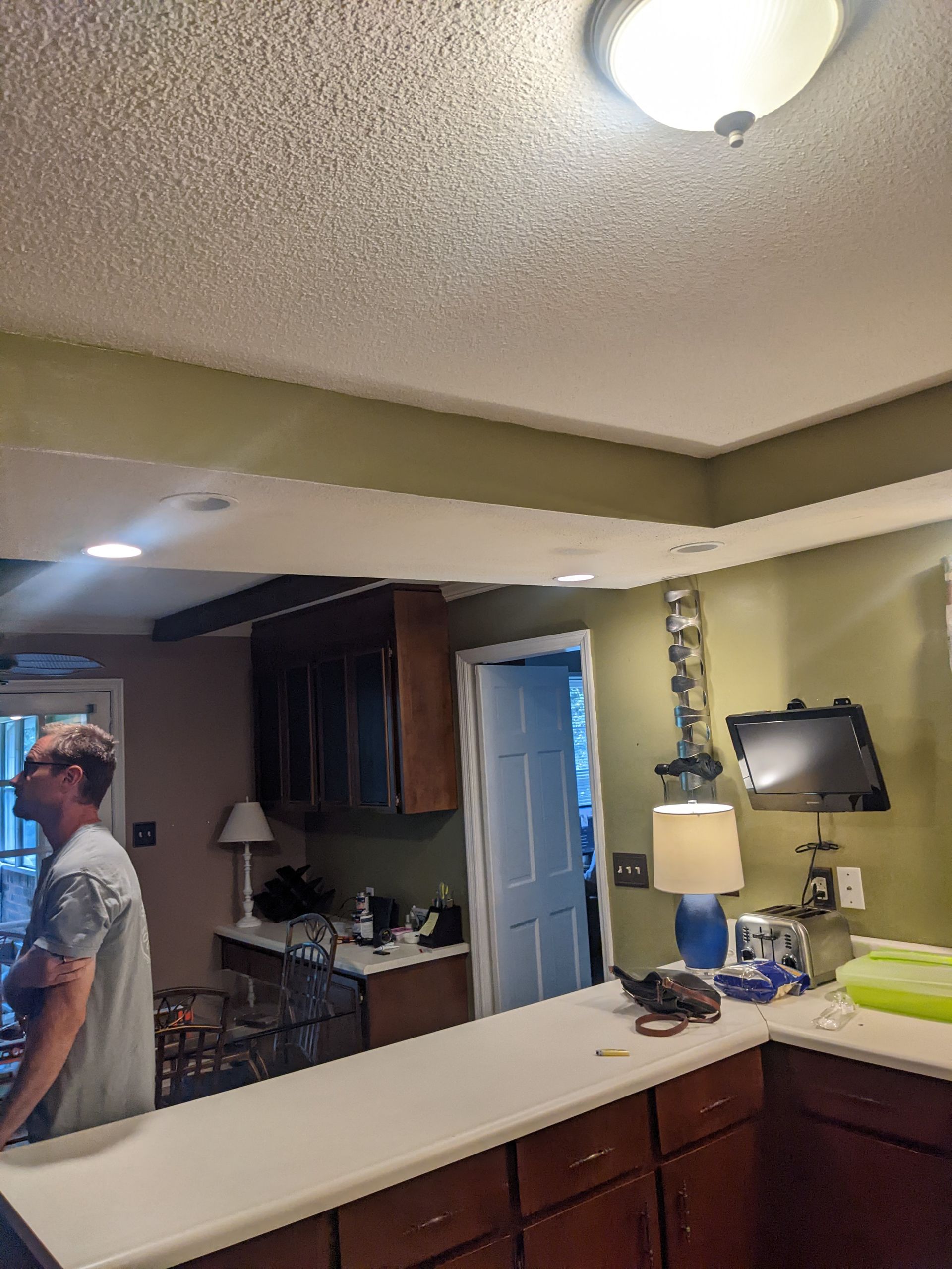A man is standing at a counter in a kitchen.