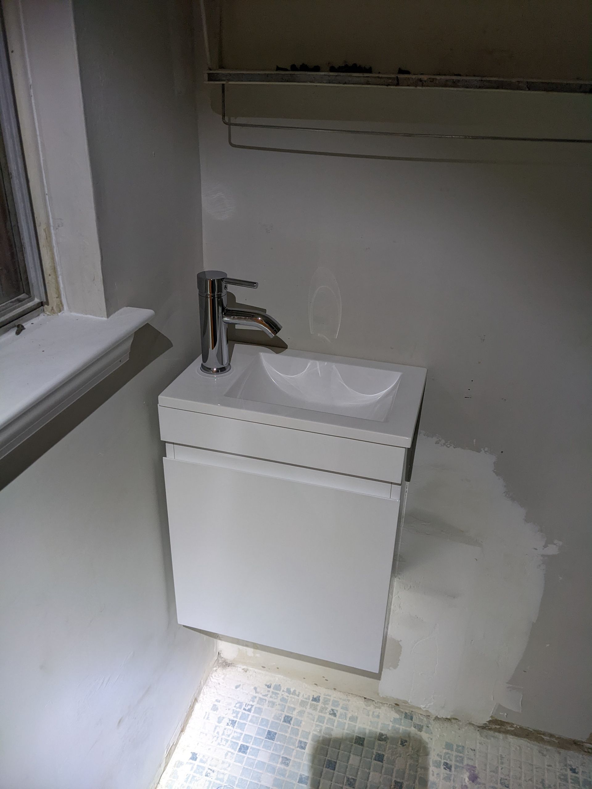 A bathroom with a sink and a window.