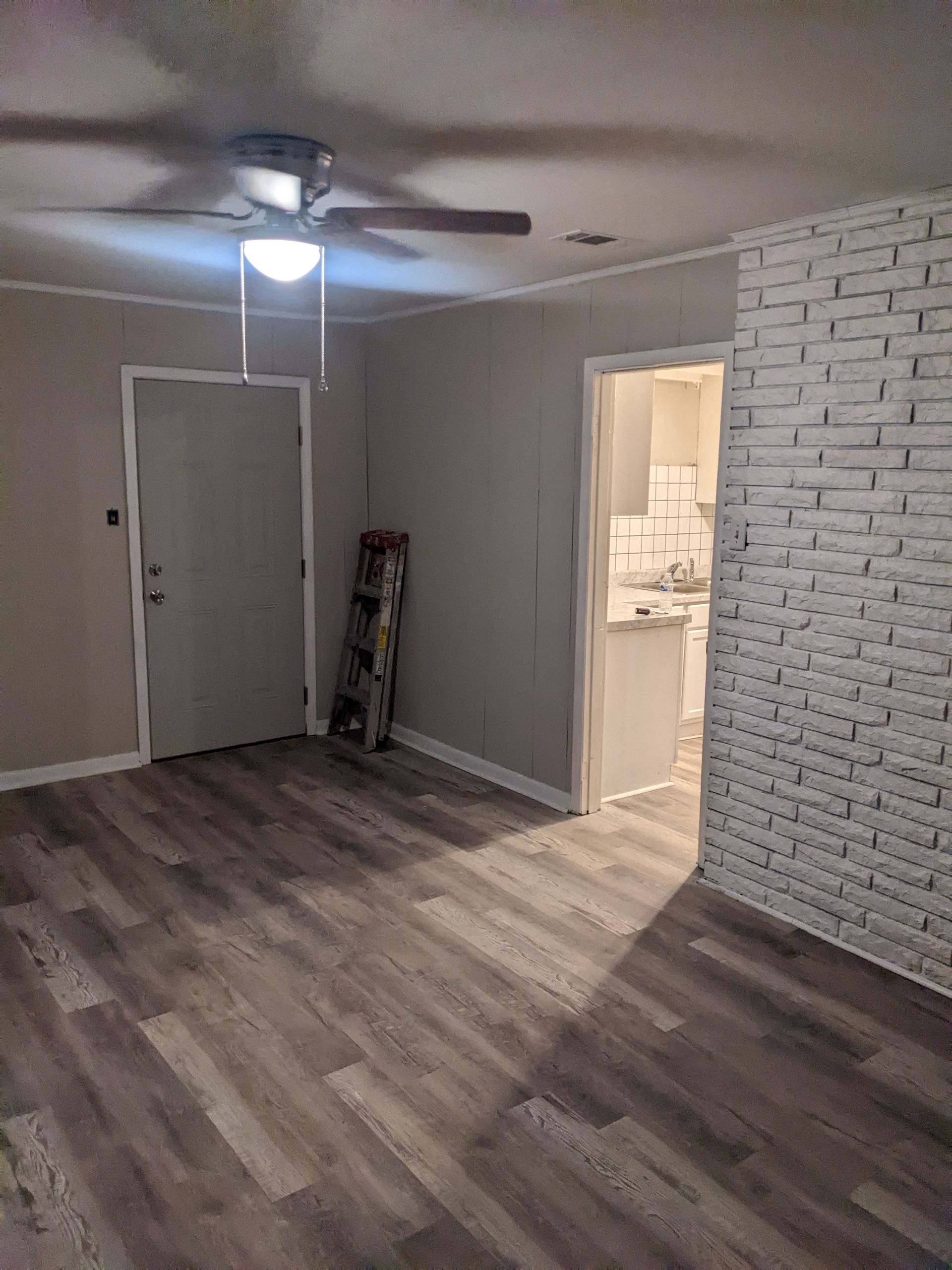 A living room with hardwood floors and a ceiling fan.
