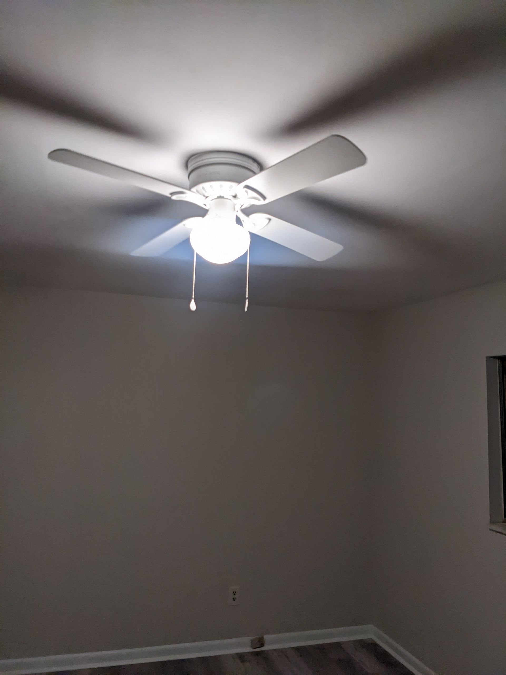 There is a ceiling fan in the corner of the room.