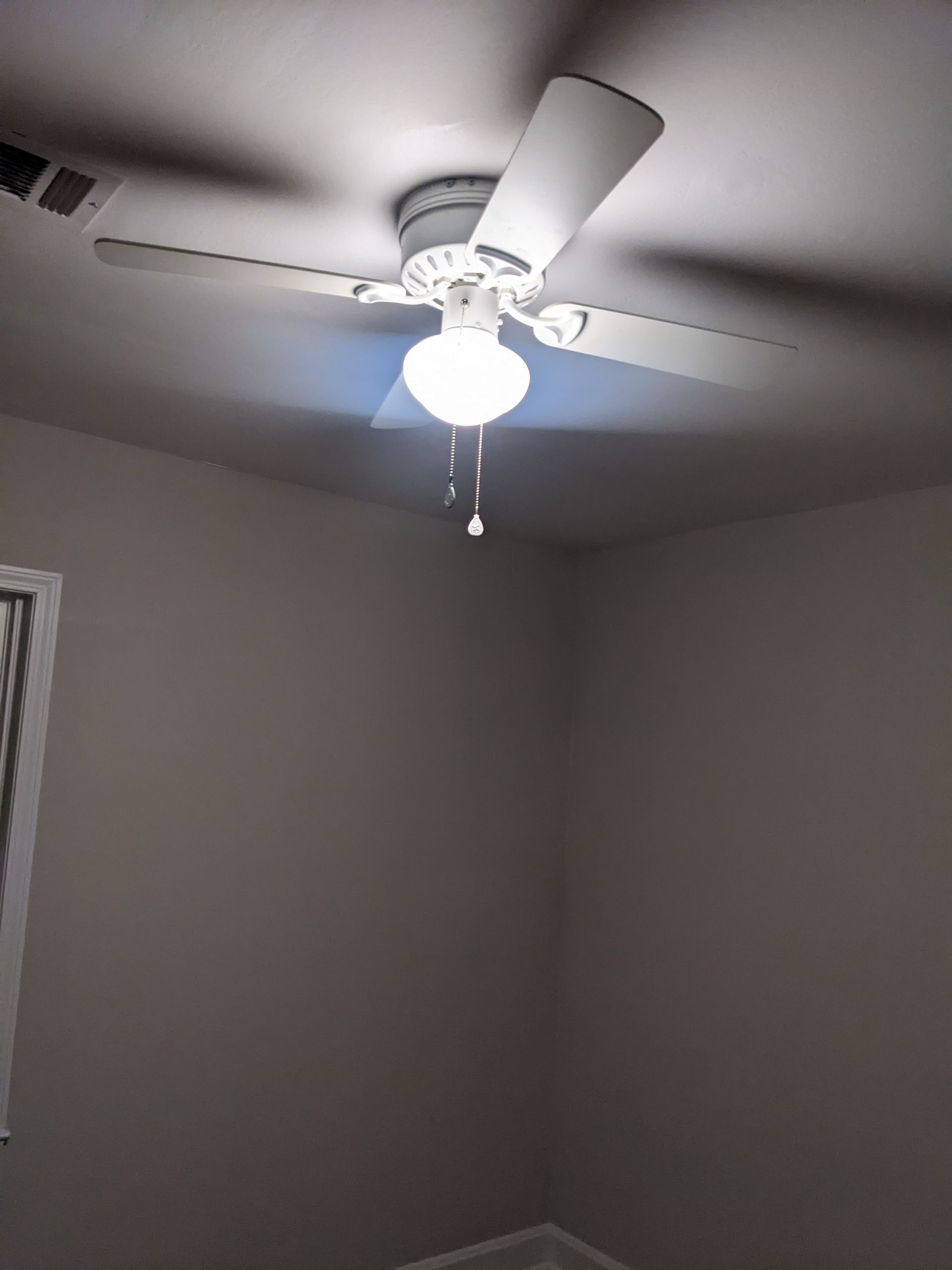 A ceiling fan is hanging from the ceiling of a room.