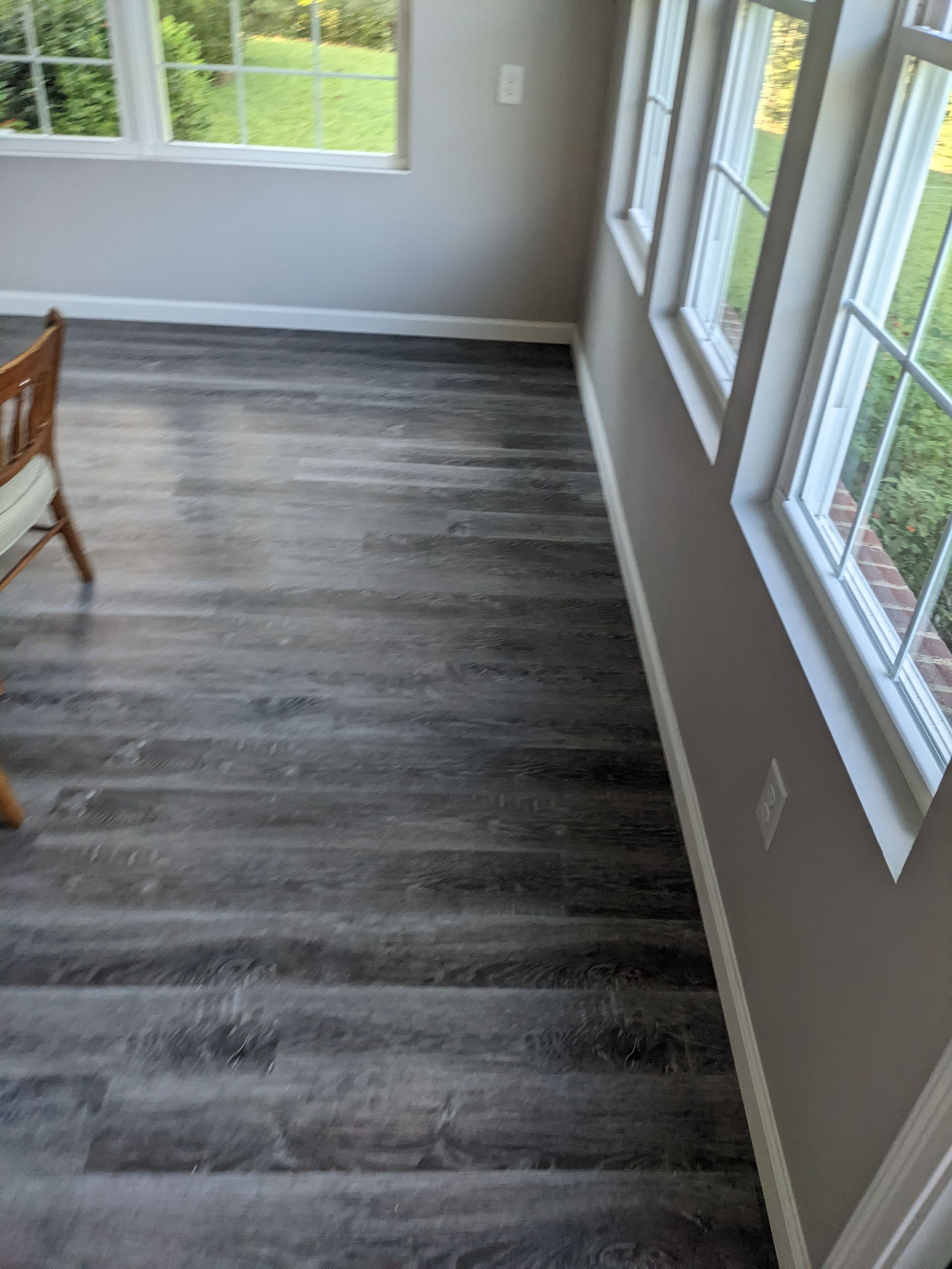 A room with a wooden floor and a chair in it.