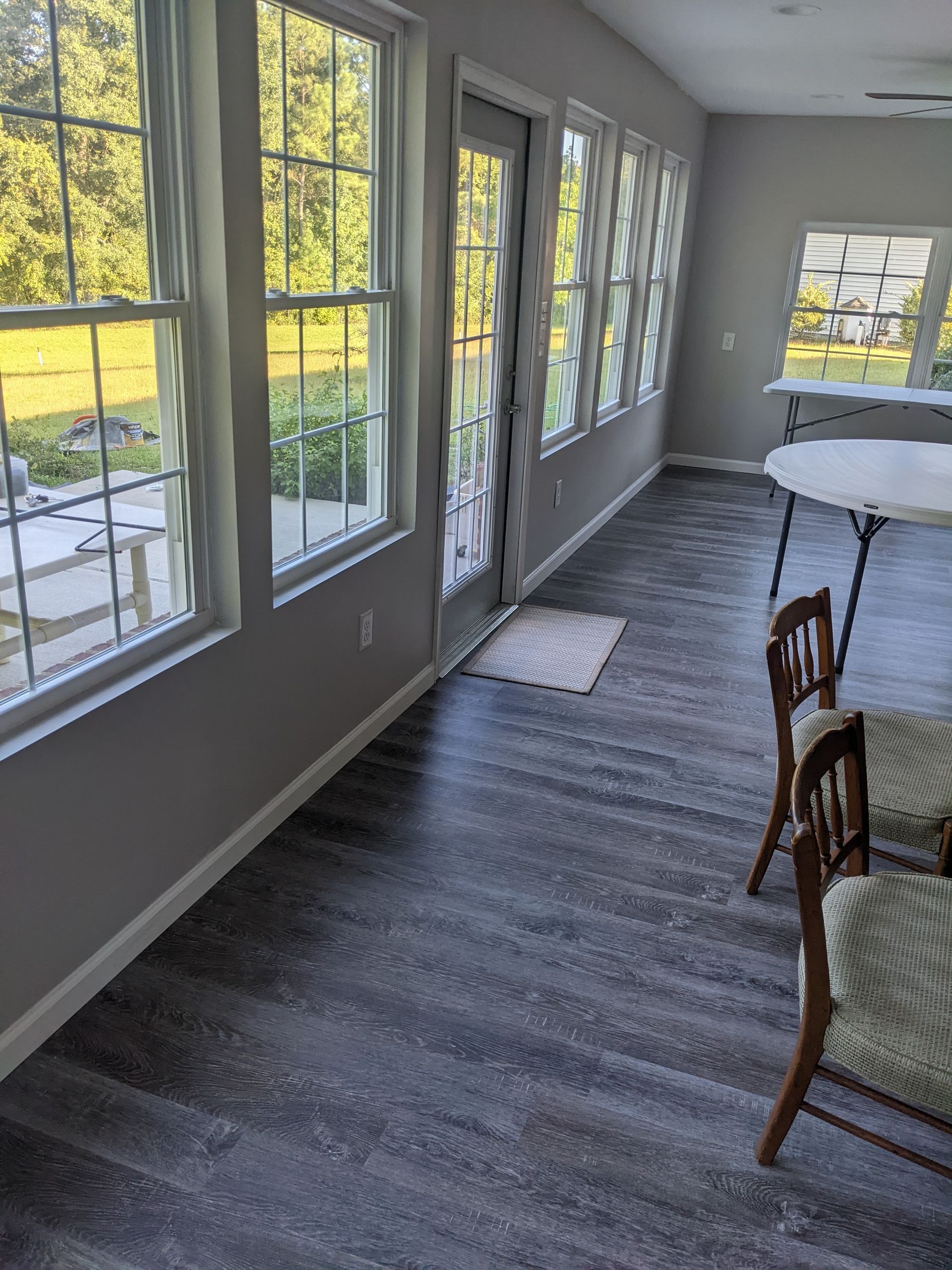 A room with a lot of windows and a table and chairs.