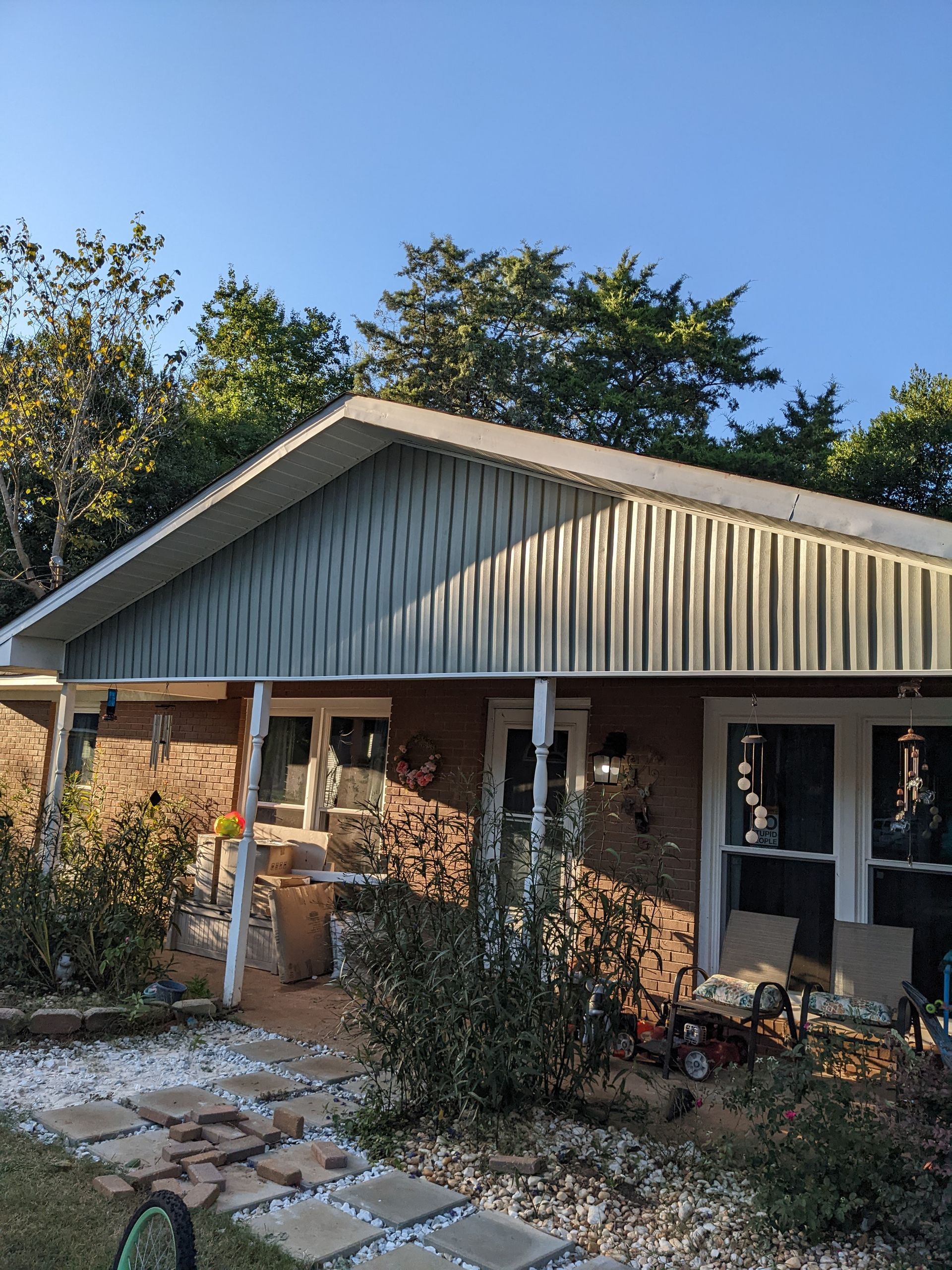 A brick house with a metal roof and a porch