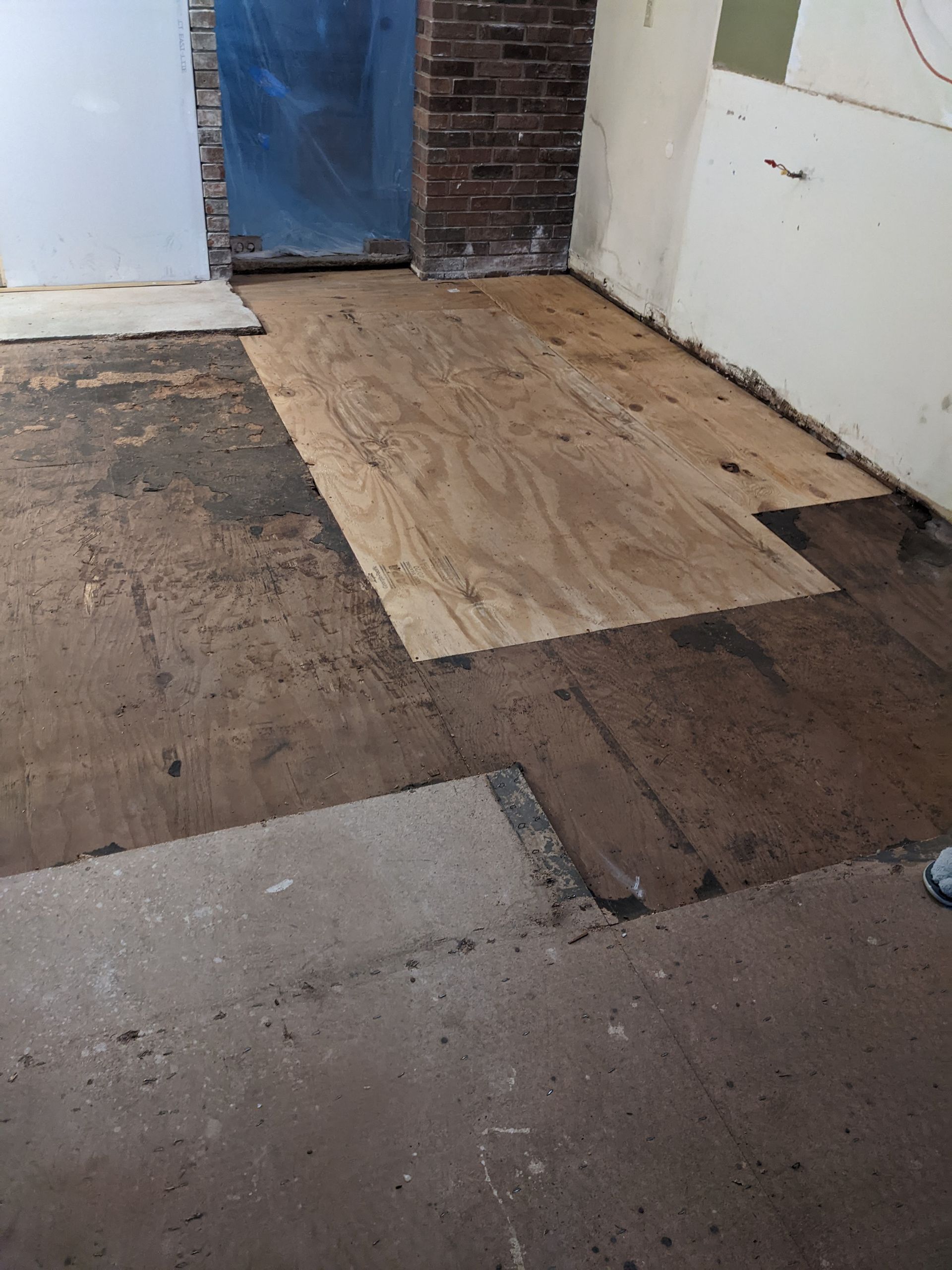 A room with a wooden floor and a brick wall.