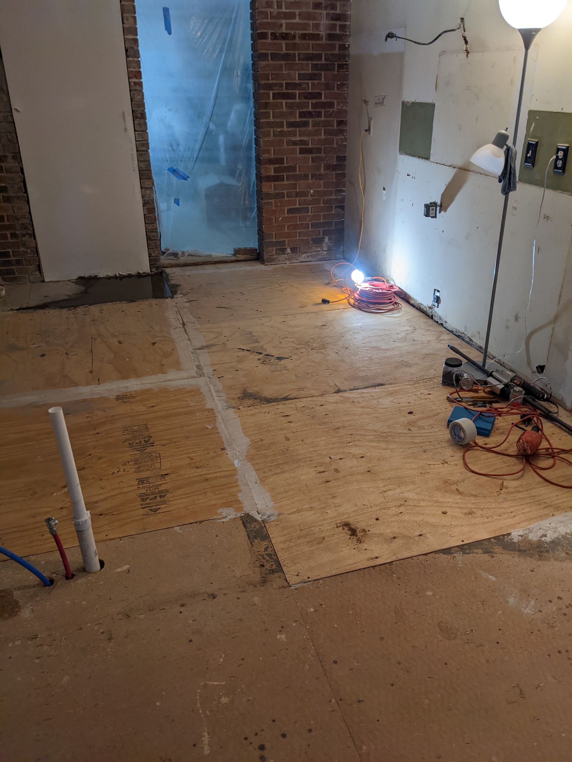 A room with a wooden floor and a lamp on the floor.