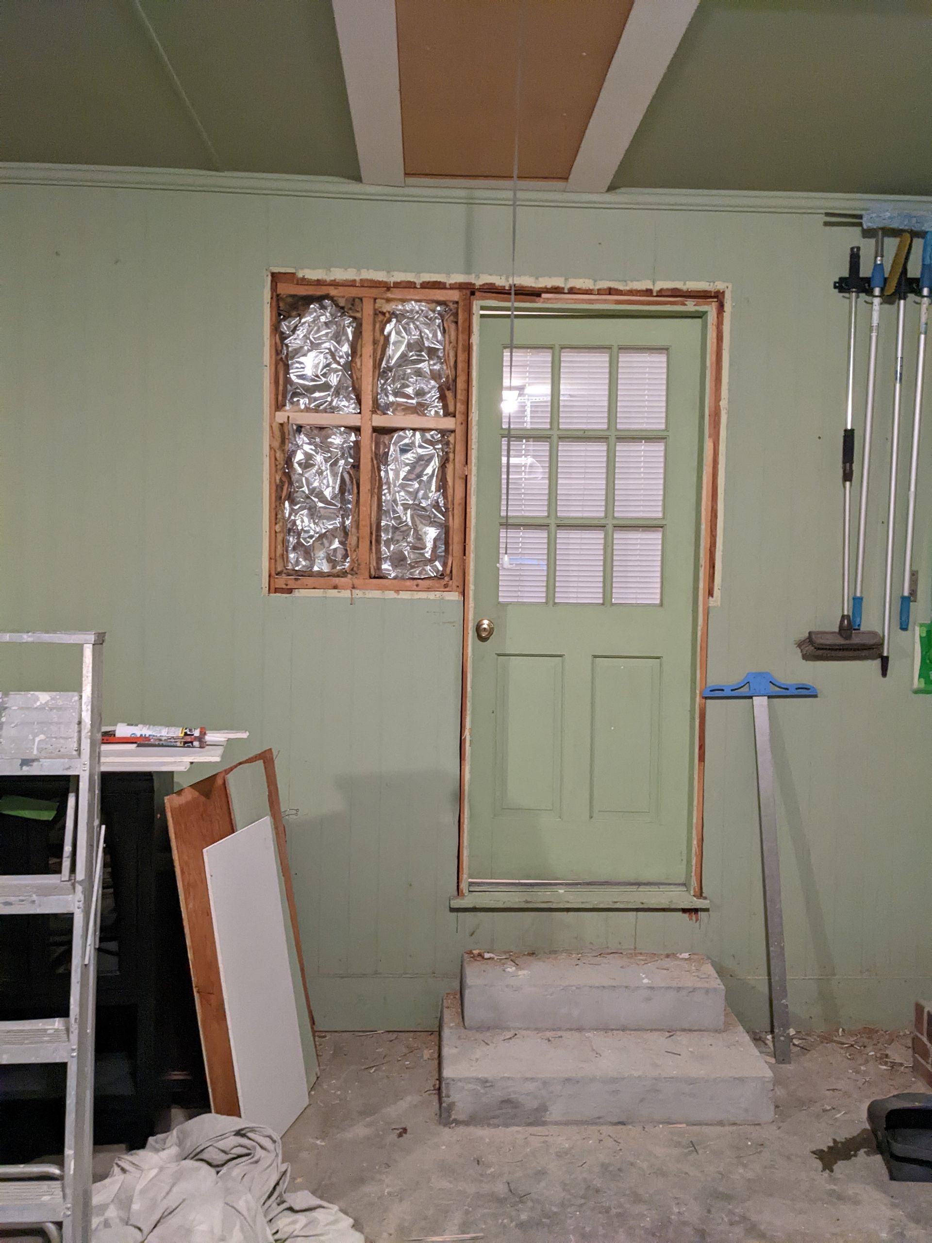 A room with a green door and a window