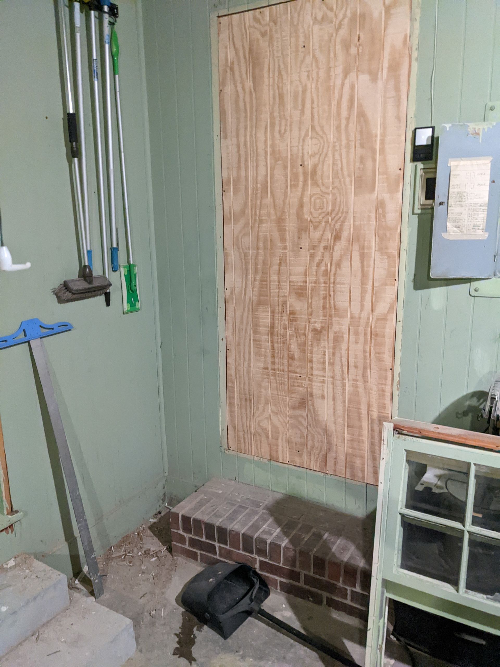 A room with a brick wall and a wooden door.