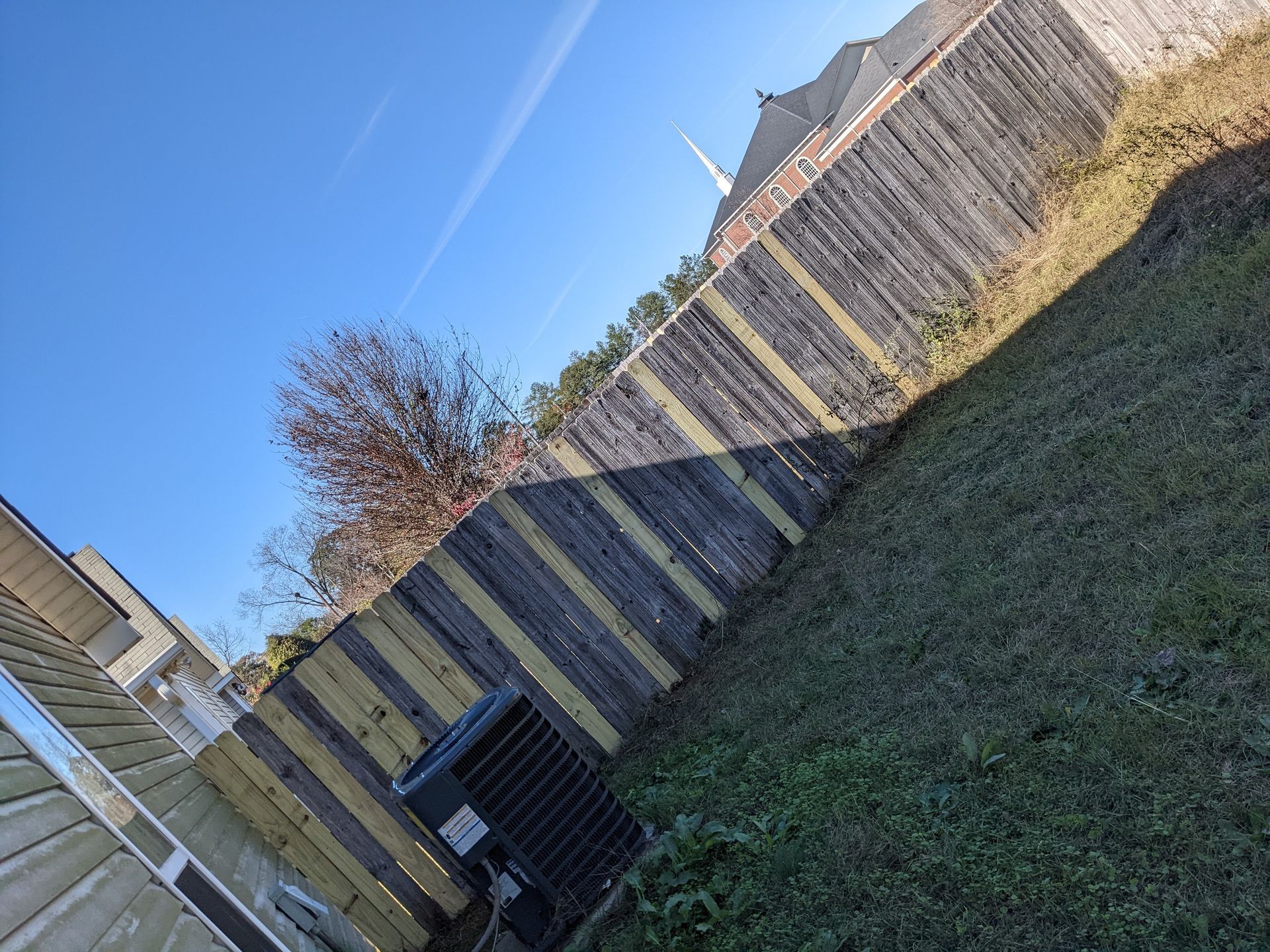 A wooden fence is in the backyard of a house